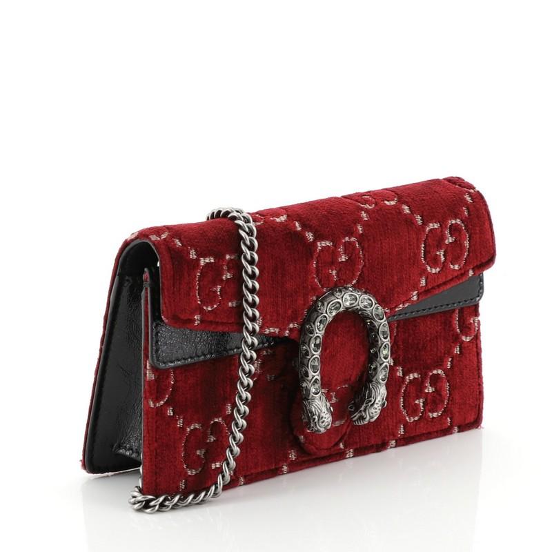This Gucci Dionysus Bag Velvet Super Mini, crafted from red velvet, features chain link strap, textured tiger head spur detail on its flap, and aged silver-tone hardware. Its hidden push-pin closure opens to a neutral microfiber interior.
