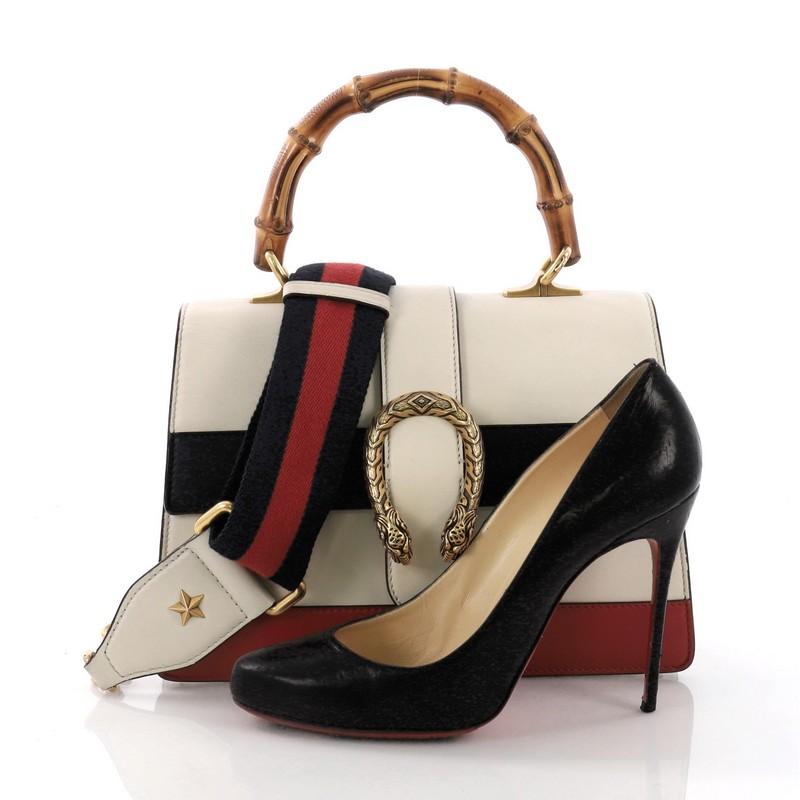 This Gucci Dionysus Bamboo Top Handle Bag Colorblock Leather Medium, crafted from white colorblock leather, features a bamboo top handle, textured tiger head spur detail, and gold-tone hardware. Its hidden push-pin closure opens to a beige fabric