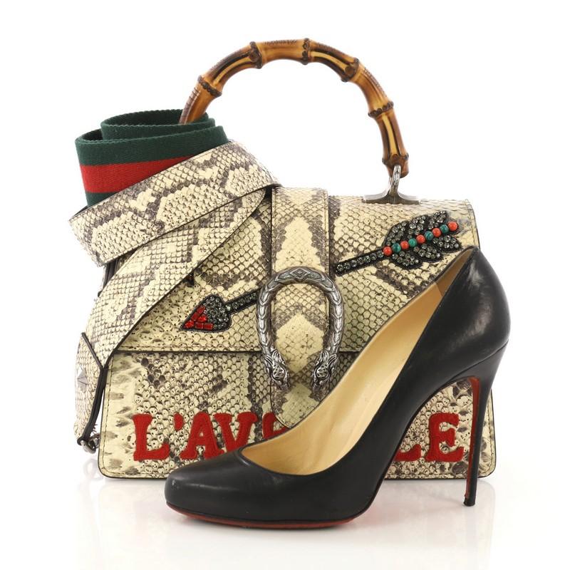 This Gucci Dionysus Bamboo Top Handle Bag Embroidered Python Medium, crafted in beige embroidered genuine python skin, features an embellished crystal-encrusted arrow and applique with the phrase 