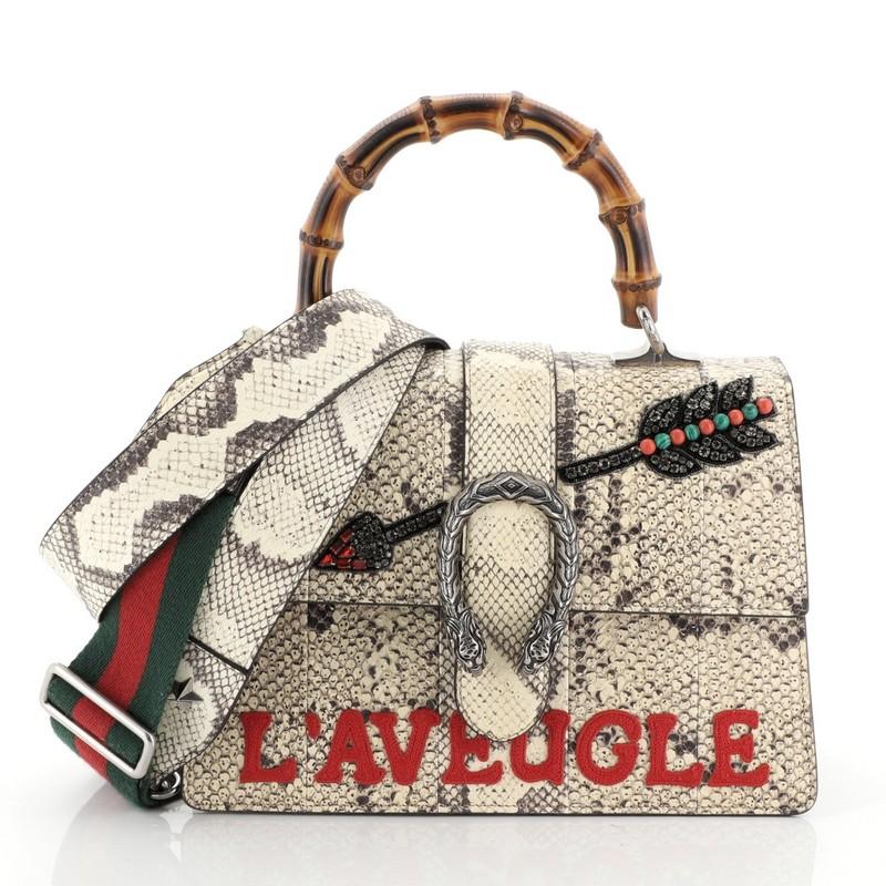 This Gucci Dionysus Bamboo Top Handle Bag Embroidered Python Medium, crafted in neutral embroidered genuine python skin, features an embellished crystal-encrusted arrow and applique, bamboo top handle, textured tiger head spur detail and aged