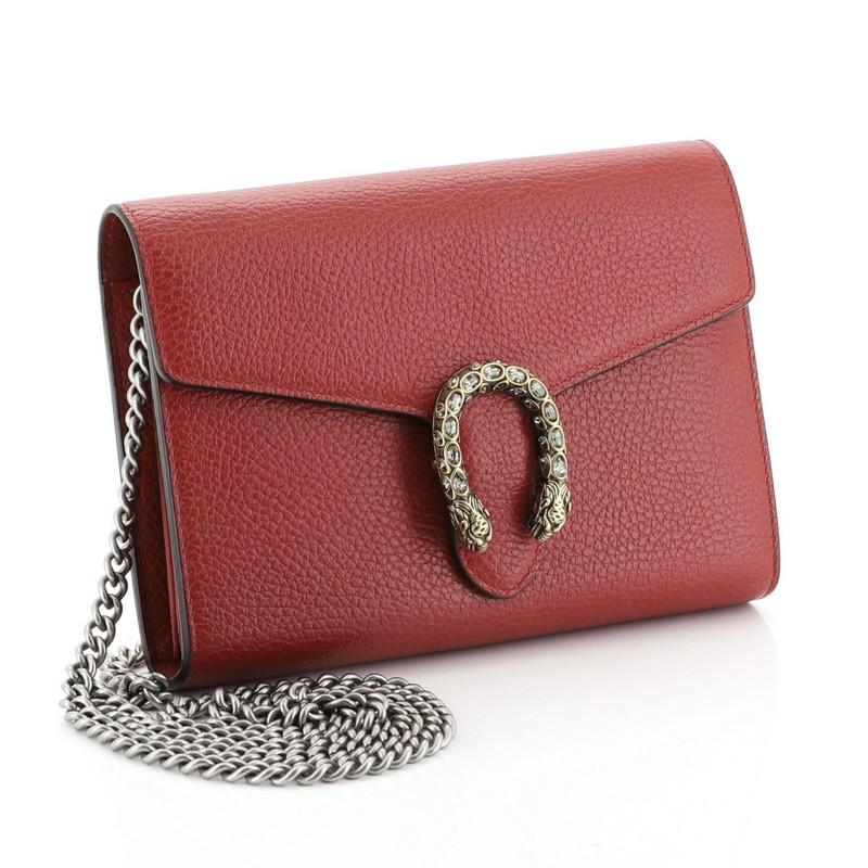 This Gucci Dionysus Chain Wallet Leather with Embellished Detail Small, crafted from red leather, features chain link strap, embellished textured tiger head spur detail on its flap, and aged gold and aged silver-tone hardware. Its hidden push-pin