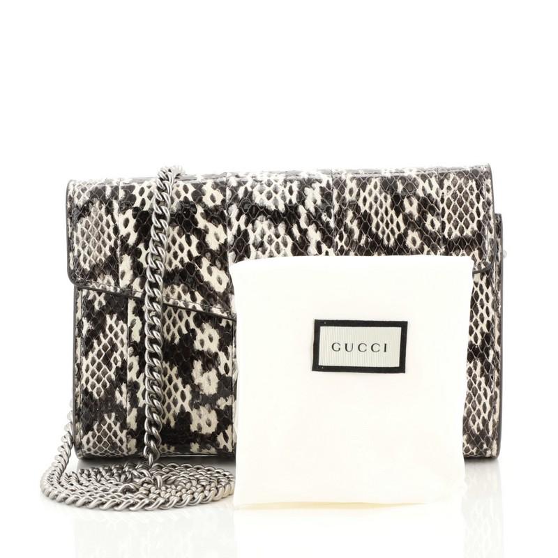 This Gucci Dionysus Chain Wallet Python Small, crafted from genuine black and neutral python, features a chain link strap, textured tiger head spur detail on its flap, and aged silver-tone hardware. Its hidden push-pin closure opens to a neutral