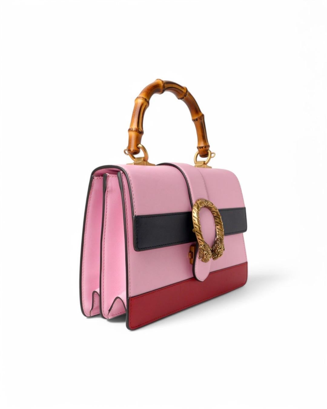 Sac Gucci signature, ligne Dionysus, en taille Medium, en cuir lisse rose avec des garnitures bleues et rouges et des ferrures dorées. Avec une fermeture à emboîtement en forme de tête de tigre, un intérieur doublé en toile beige, deux compartiments
