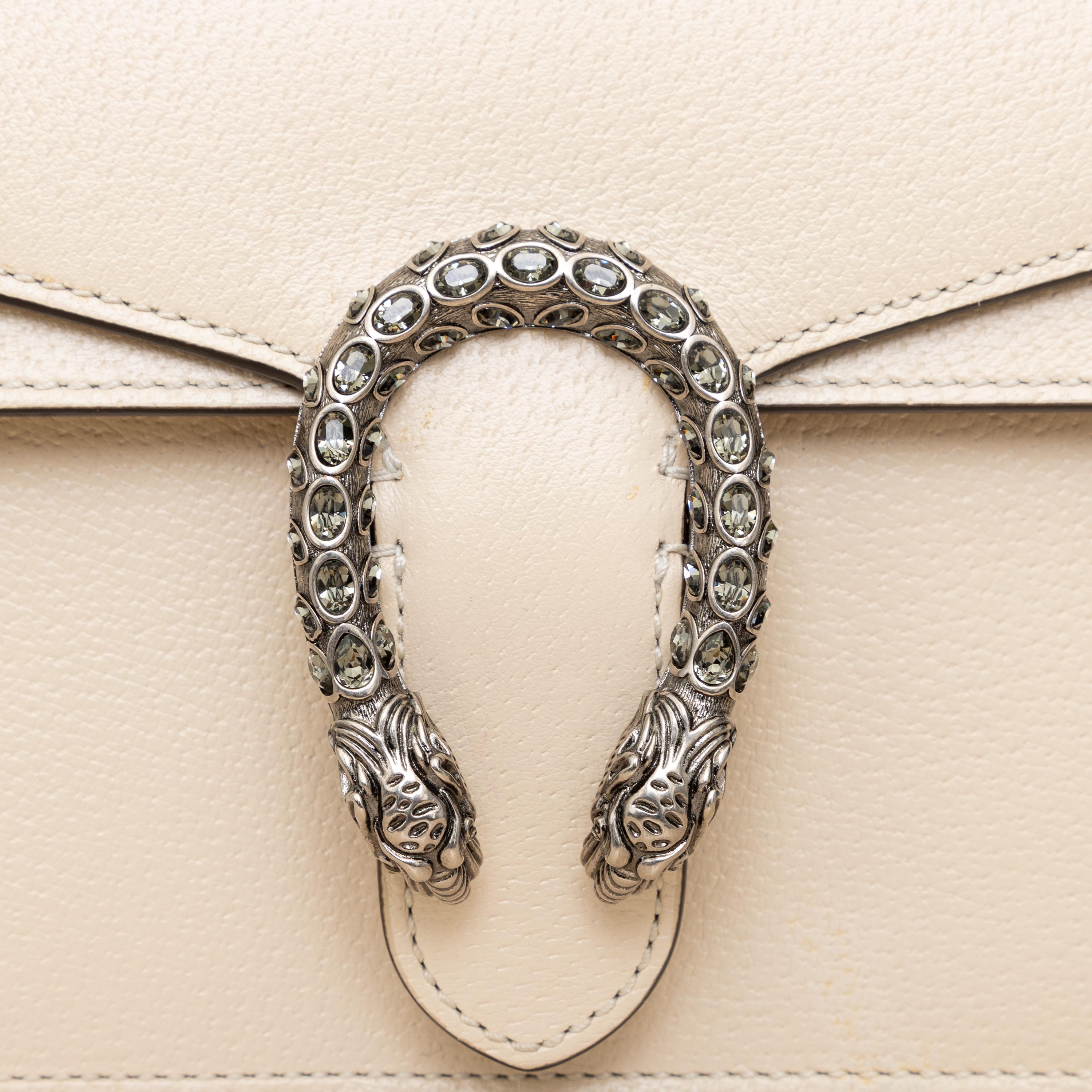 Expertly crafted in Italy, the Gucci Dionysus Mini Bag is a must-have accessory. Made of luxurious textured leather, the unique tiger head closure sparkles with crystals for added elegance. The versatile sliding chain strap offers multiple ways to