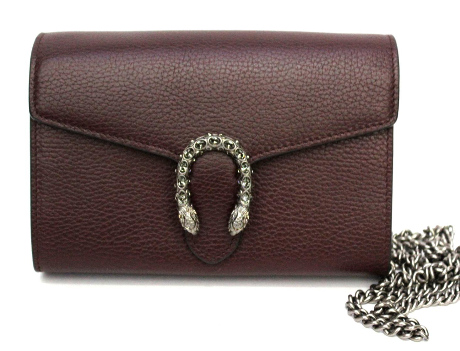 Gucci bag dionysus mini model, in burgundy leather and with chain strap. Bejeweled clasp with crystal decoration in grey tones. Coordinated interior with numerous pockets for cards and cash. The bag is also equipped with a comfortable central