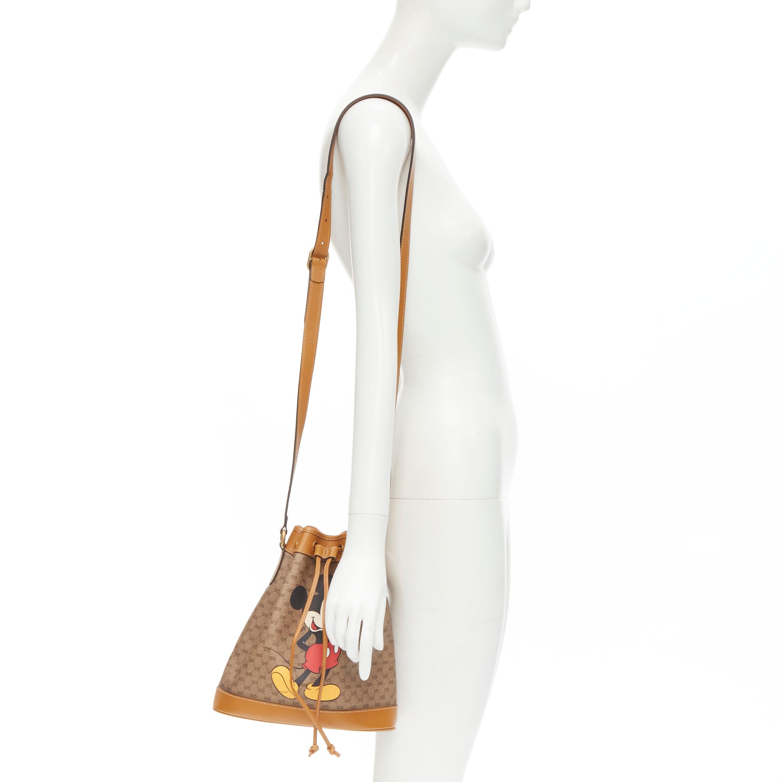 GUCCI DISNEY Candy GG Micky Mouse brown leather trim bucket bag 
Reference: JYLM/A00028 
Brand: Gucci 
Designer: Alessandro Michele 
Model: Candy GG 
Collection: Disney 
Material: Canvas 
Color: Brown 
Pattern: Mickey Mouse 
Closure: Drawstring