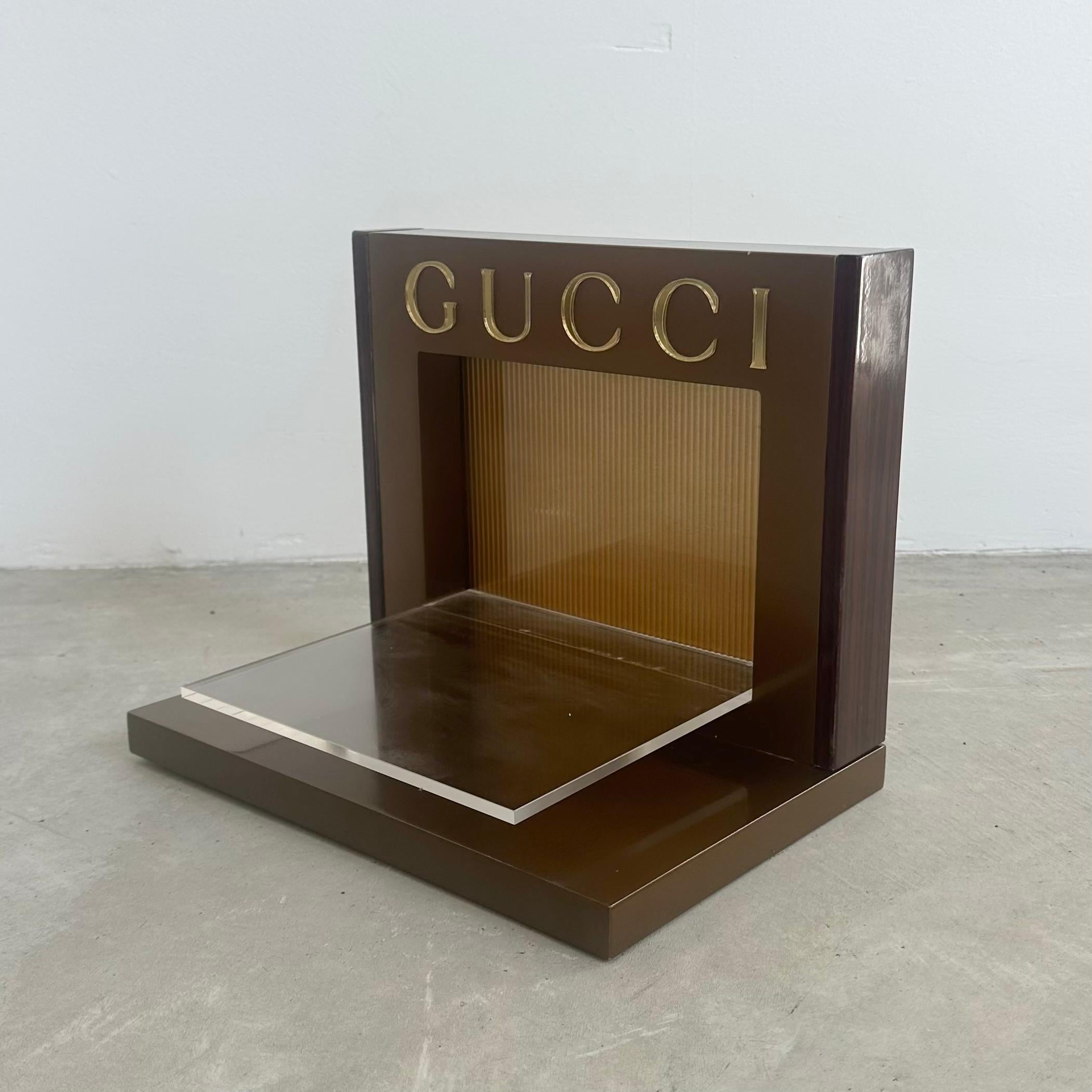 Scaffale vintage di Gucci. Molto probabilmente è stato utilizzato da Gucci come espositore per occhiali da sole o profumi. È l'ideale per esporre profumi, gioielli o altri piccoli tesori a tua scelta. 

Le doghe in Wood su entrambi i lati del pezzo