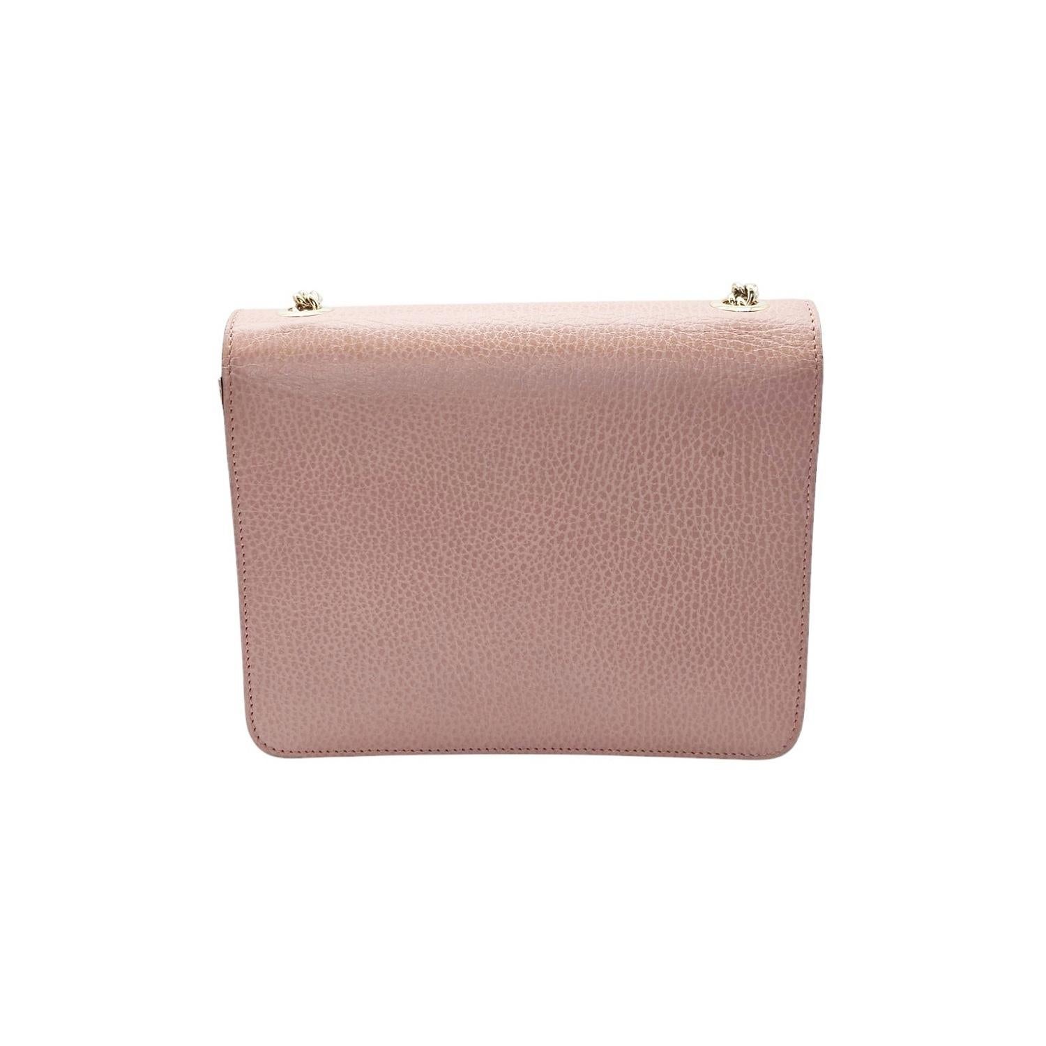 Ce sac à bandoulière Gucci Dollar Calfskin Small Interlocking G est réalisé en cuir de veau souple rose magnifiquement grainé. Le sac est doté d'une bandoulière à maillons dorés qui s'étire jusqu'à la taille et d'un rabat sur lequel est apposé