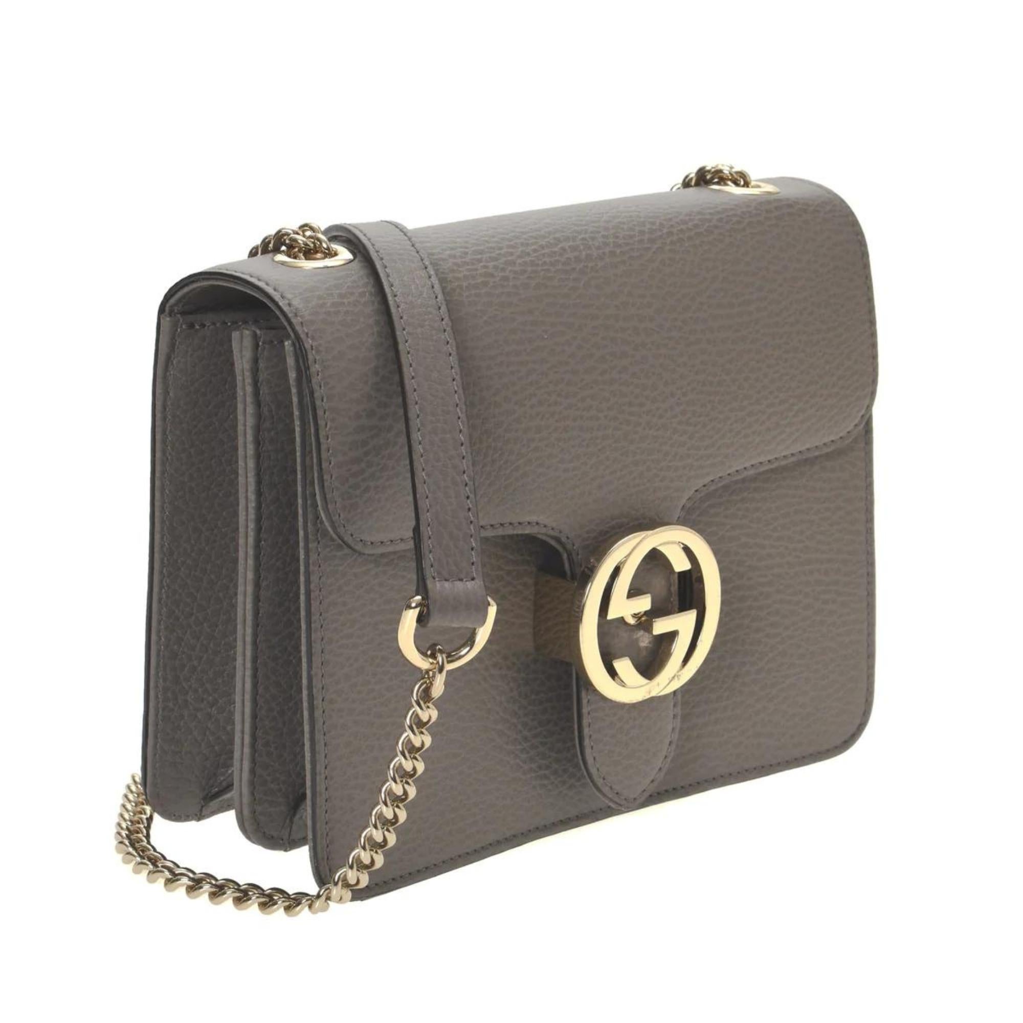 Este bolso bandolera está fabricado en piel de becerro granulada de color gris. El bolso presenta herrajes en oro claro pulido, una correa de eslabones de cadena con hombrera de piel y una solapa superior cruzada con cierre de flip lock GG