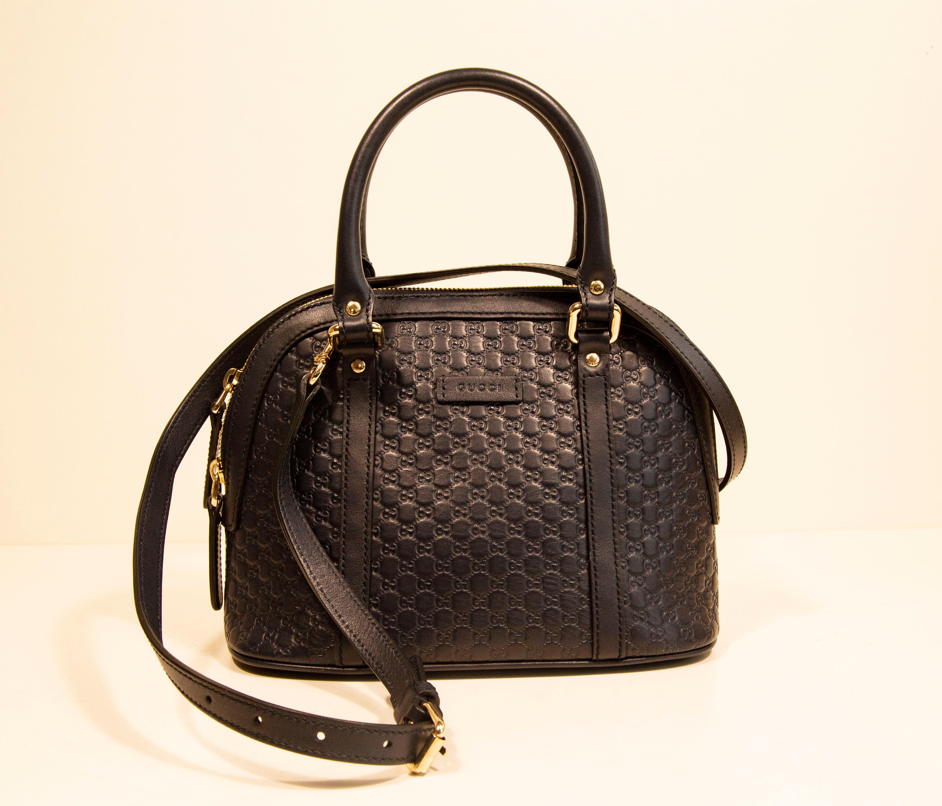Eine Gucci Dome Crossbody Bag /Top Handle Bag aus mini GG Guccissima geprägtem navyblauem Leder. Die Tasche ist mit leicht goldfarbenen Beschlägen versehen. Der Innenraum ist mit grauem Segeltuch ausgekleidet und verfügt neben dem Hauptfach über ein