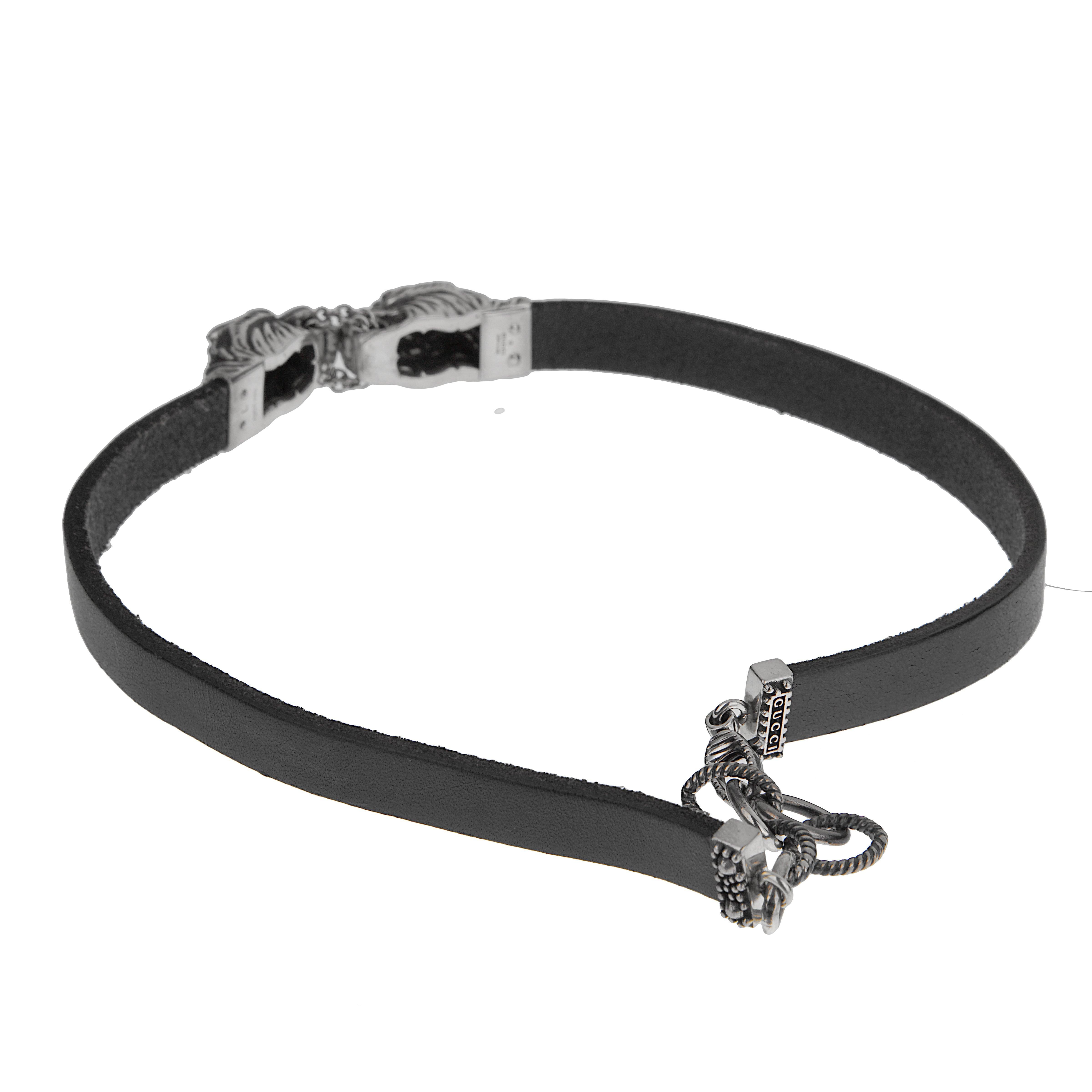 La collana con testa di tigre in pelle e argento di Gucci emana un'eleganza cruda e un potere dominante. Realizzato in Italia, questo pezzo combina perfettamente l'elegante pelle nera con l'estetica feroce dell'animalier, rendendolo un accessorio di