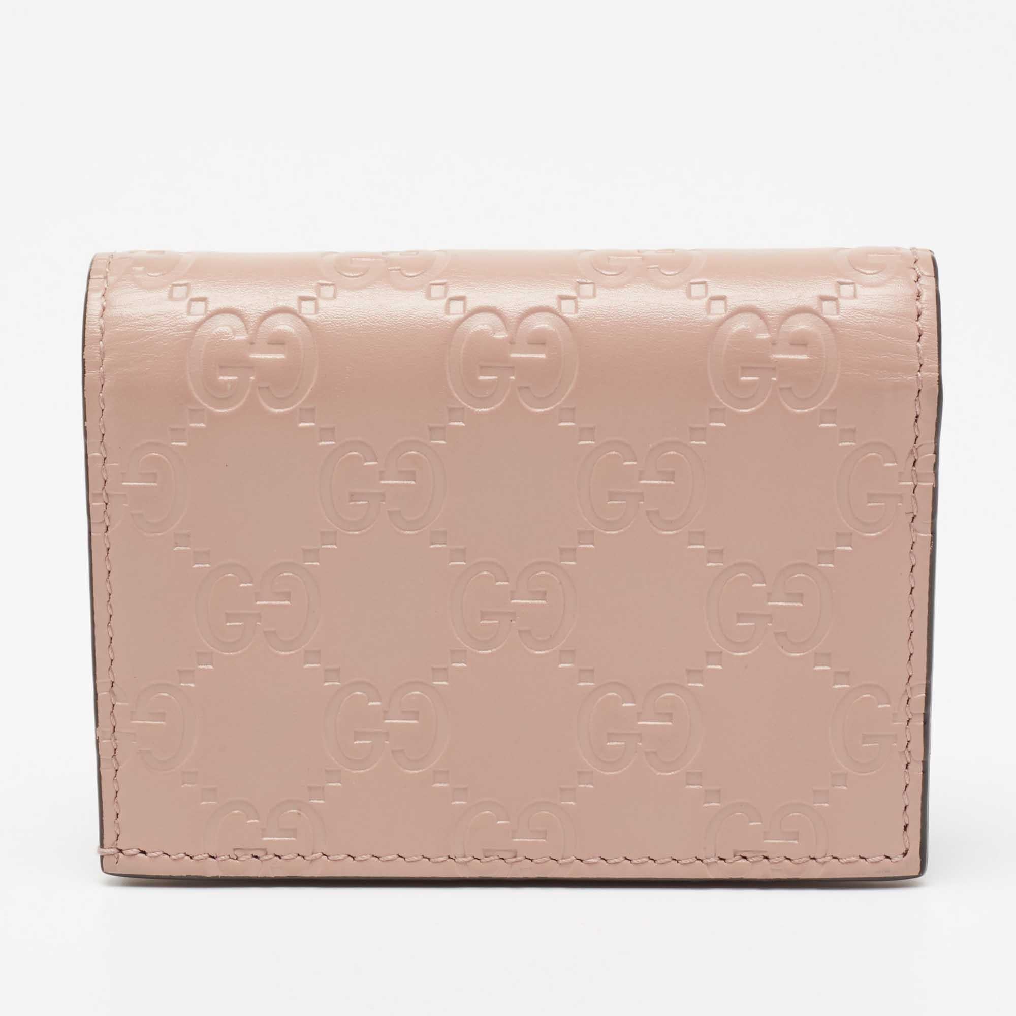 This Gucci card case is an accessory of utility. Made from Guccissima leather, its front flap is adorned with a branded bow and its compartmentalized interior will keep your cards organized.

