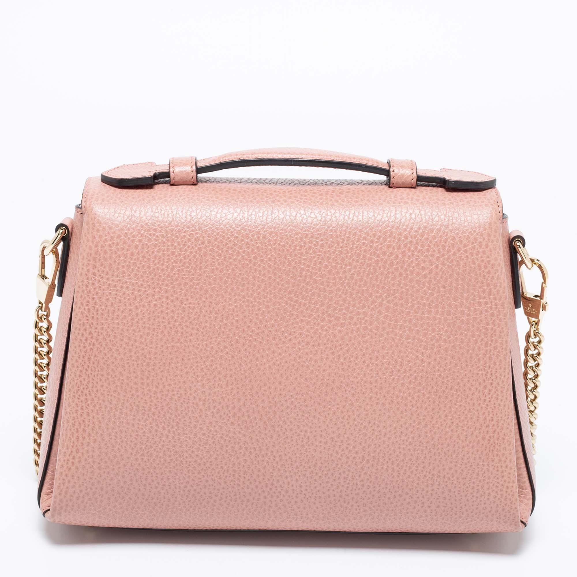 Elegance meets luxury in this stunning bag from the House of Gucci. It is created using dusty-pink leather, with an Interlocking G motif perched on the front. It features a fabric-lined interior, gold-tone hardware, and a sturdy top handle. This