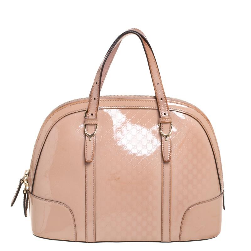 Meticulously crafted from Microguccissima patent leather, this Gucci bag delights not only with its appeal but structure as well. It is held by two top handles, detailed with gold-tone hardware, and equipped with a spacious canvas interior. The