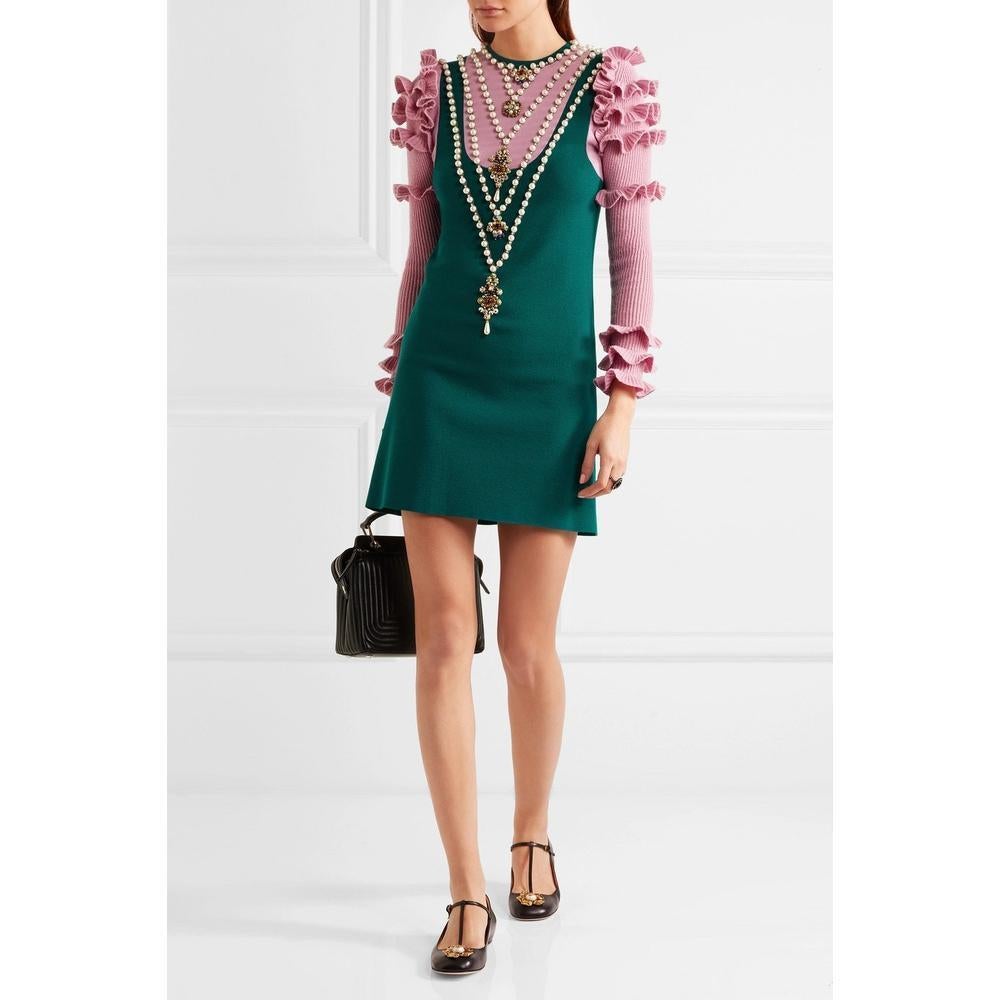 This mini dress is one of our favorite looks.
Knitted from a sumptuous wool-blend, this teal and lavender dress has ruffled sleeves and is adorned with faux pearls, beads and crystals to look like layered necklaces.
Wear yours with bare legs and
