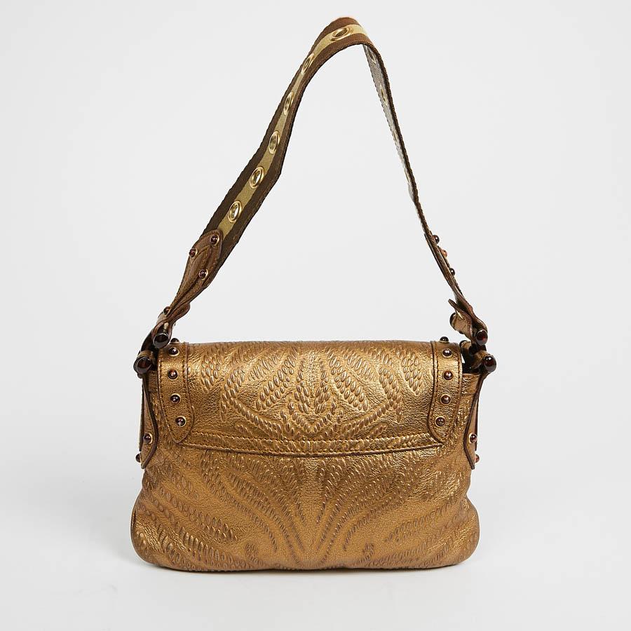 Lovely Gucci embossed leather handbag. It is vintage gold leather embellished with tortoiseshell-style pieces. It closes with a flap with a tongue that slides under a bit symbolizing the brand. The hardware is in gilded brass. It can be carried by