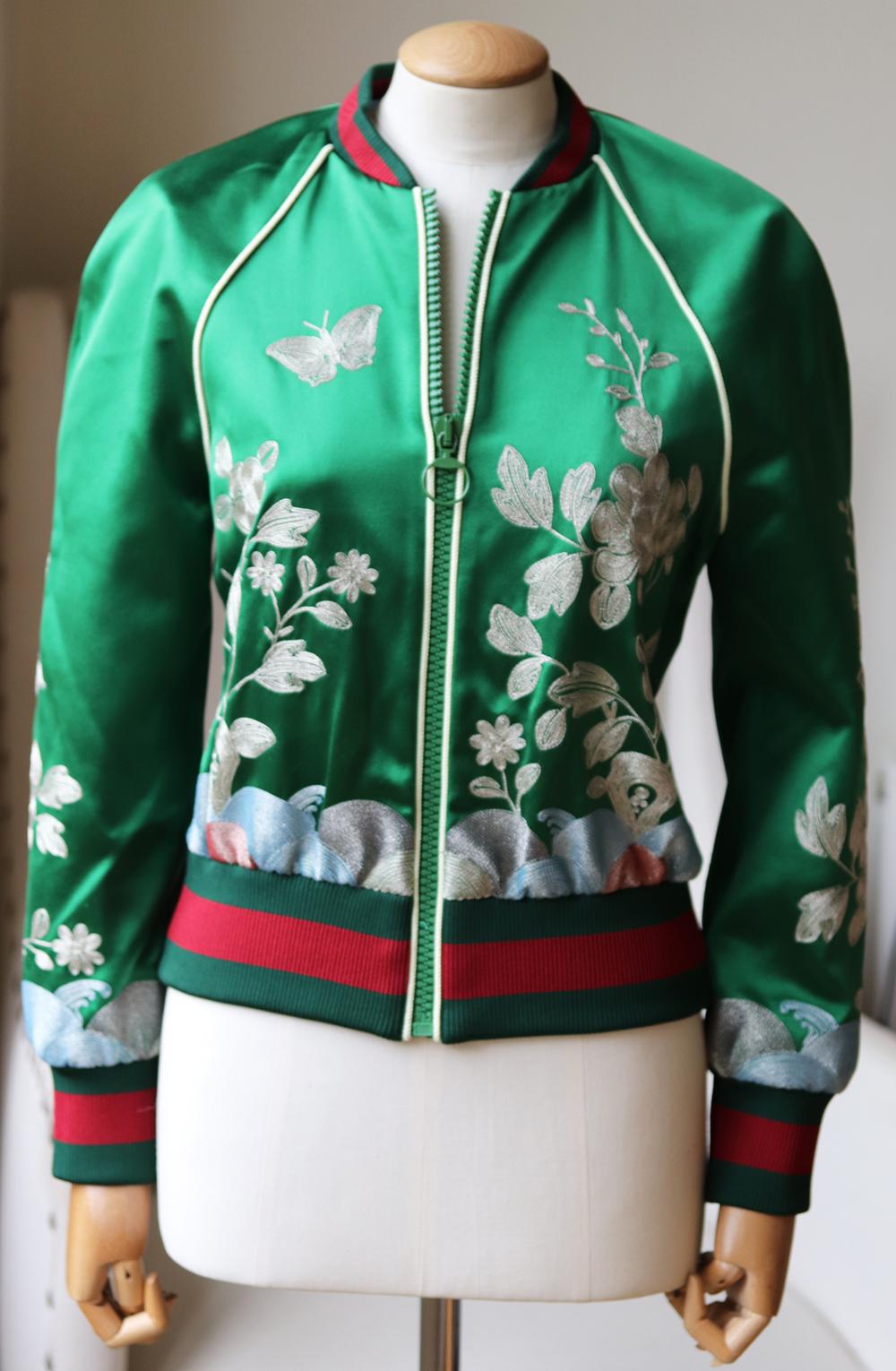 Gucci's statement bomber jackets have been a key feature of every season as they are easy to dress up or down. 
Designed with the brand's signature red and green ribbed trims, this silk-satin style is decorated with metallic floral