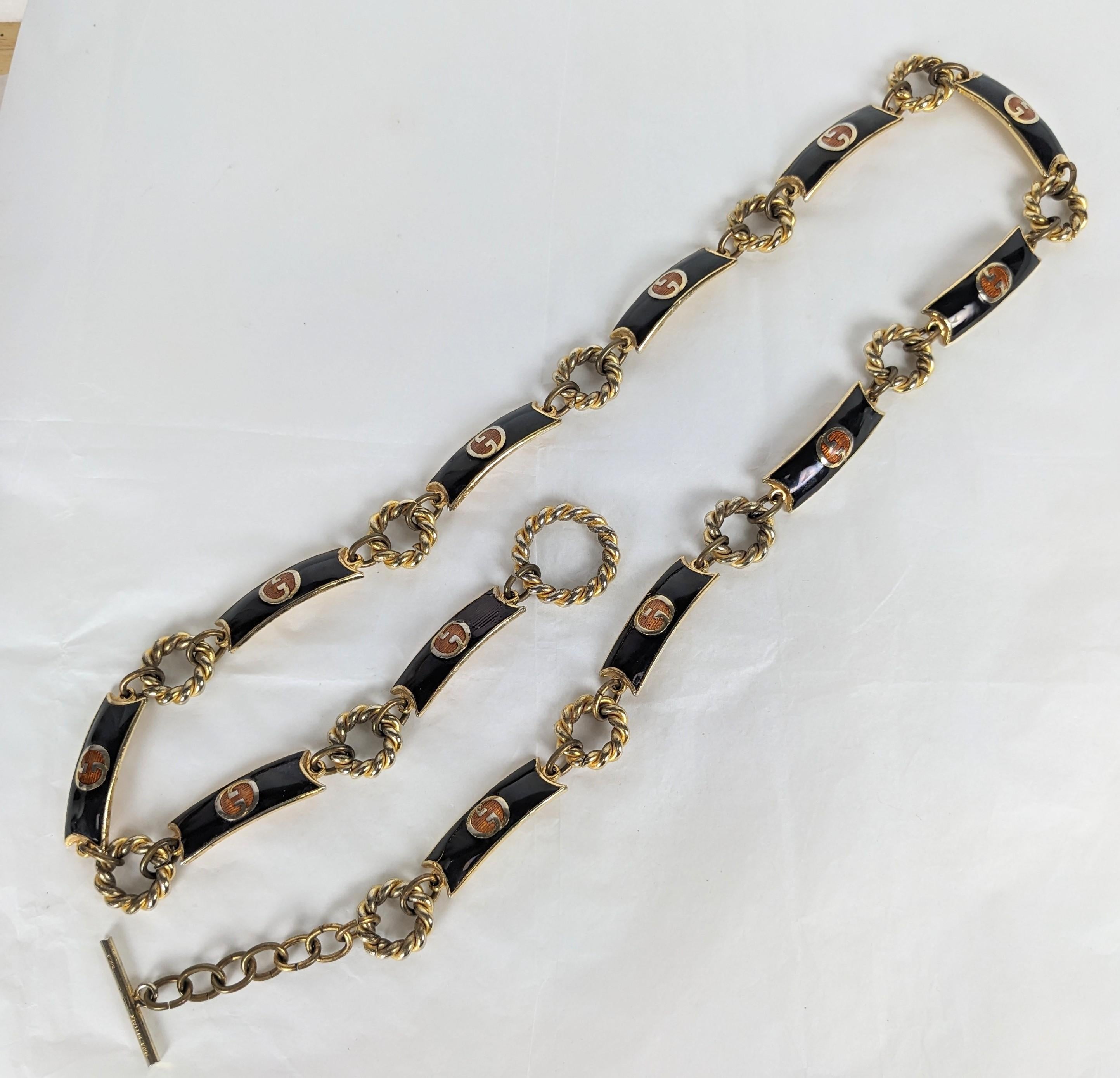 Vintage Gucci Emaille Logo Gürtel aus den 1970er Jahren. Emaille-Logo-Glieder in Schwarz und Gold mit verstellbaren Gliedern. Kann auch als Halskette getragen werden. Signiert auf T-Bar, Gucci, Made in Italy. 1970's. Maximale Länge 34
