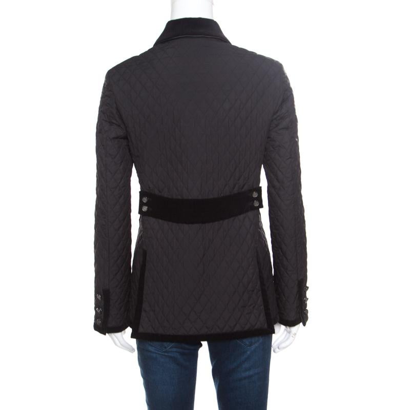 This quilted jacket from Gucci is sure to make you stand out and is a perfect blend of comfort and style! The black creation is made of a blend of fabrics and features a quilted design pattern. It flaunts velvet trim detailed wide collars, front
