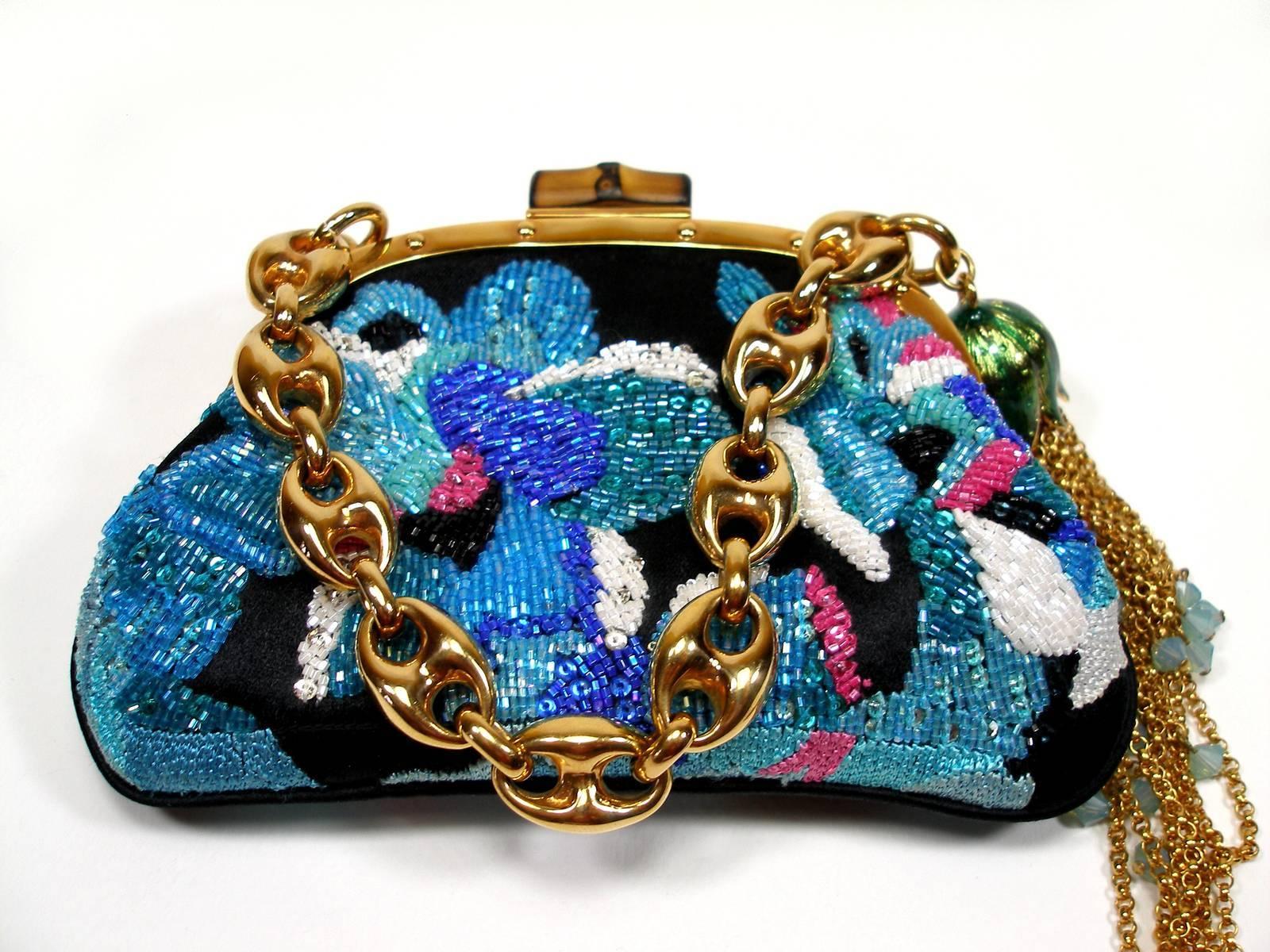 Amazing Gucci Mini evening minaudière in silk embroidered with glass beads and enriched with beautifully made floral charms.
The Bamboo lock and the Marina chain are historical iconic elements of the Italian maison.
The inside is in golden