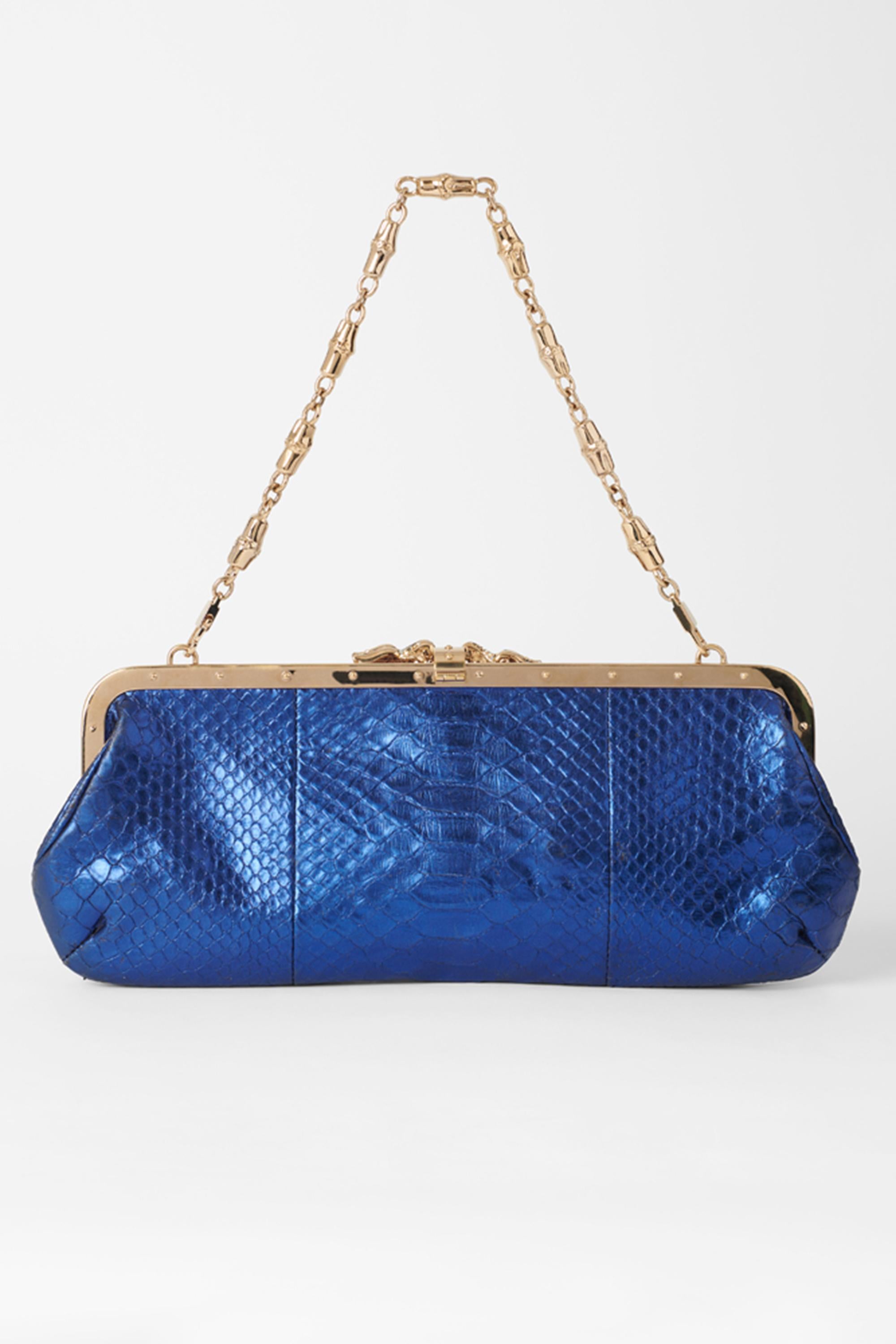Nous sommes heureux de vous présenter cette pochette bleue Gucci by Tom Ford Fall Winter 2004. Il est orné d'un dragon au centre perlé, d'un corps en serpent bleu irisé, d'une chaîne d'épaule dorée détachable et d'une poche intérieure au dos. En