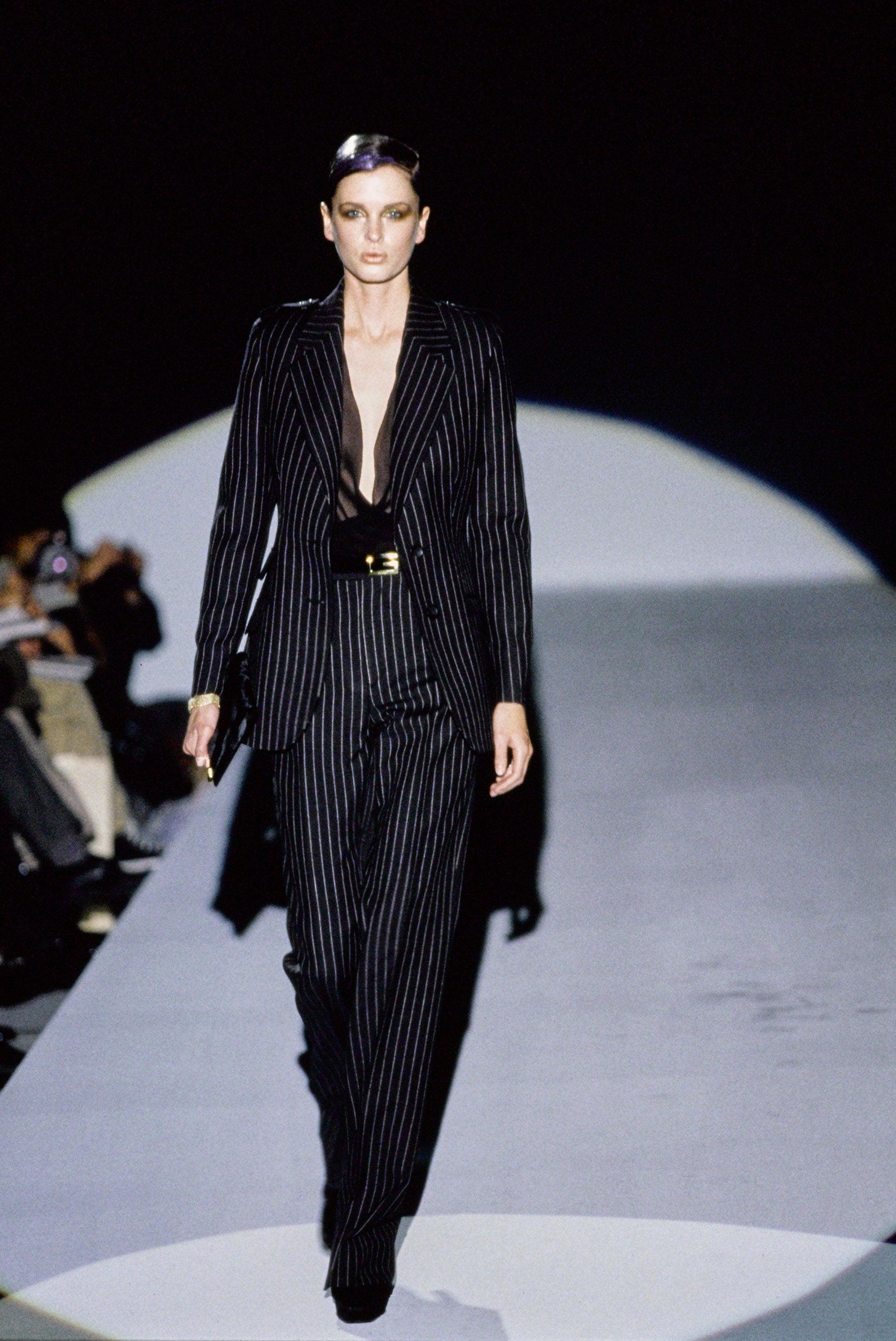 Vintage Gucci
By Tom Ford
Fall 1996 - seen on the runway, in a Vogue July 1996 editorial, and longer jacket version seen in campaign image

Black pinstriped jacket & trouser suit set
Military style jacket with epaulet shoulder detail
Slightly padded