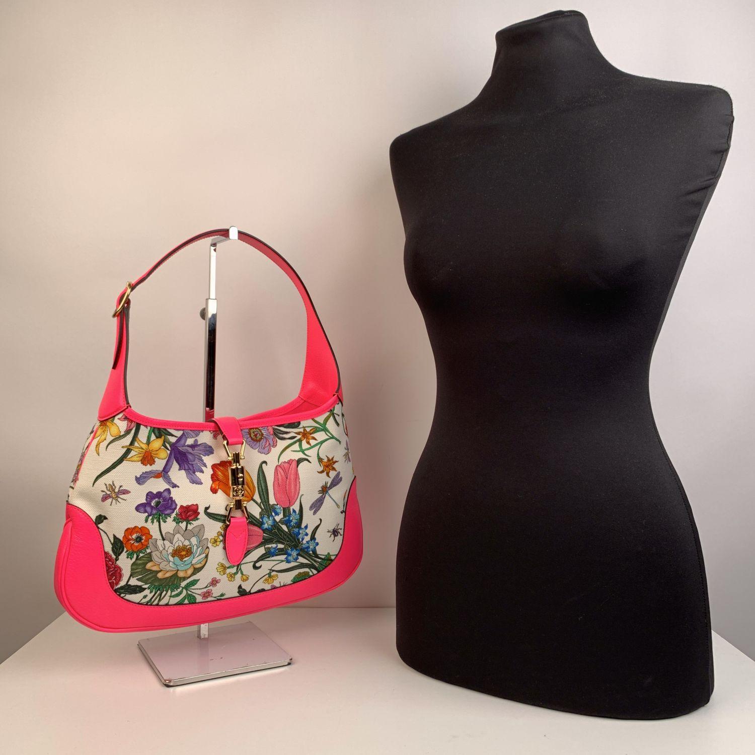 Beautiful Gucci 'Flora' Medium Jackie Bag. The bag is crafted in 'Flora' canvas with fuchsia leather trim and handle, Gold metal piston classic 'Jackie' closure. Canvas internal lining. Phone pockets and other side zipper pocket inside. 'GUCCI -