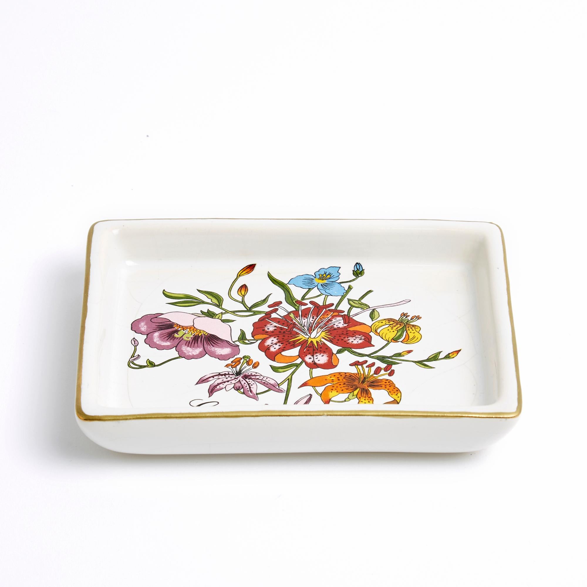 Gucci pocket tray, Flora model, probably circa 1995, in ecru-colored porcelain with floral pattern, gold thread around the edge, signed. Width 13.3 cm x Length 13.3 cm x width 10.5 cm x height 2.2 cm. The pocket tray has been used and the porcelain