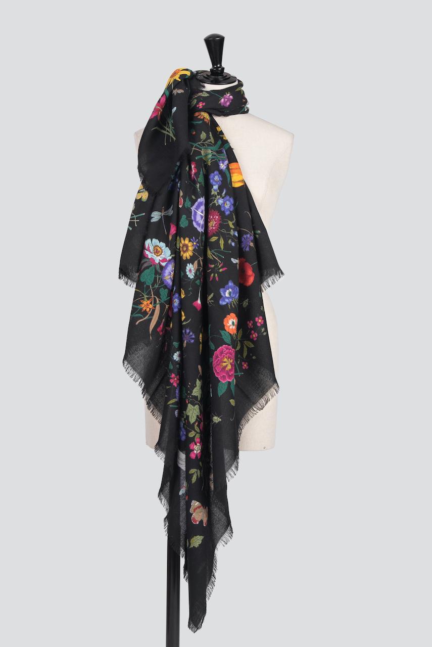 This is a wonderful and fine c. late 1970s huge Gucci wool scarf. It features the historic Flora motif designed by Vittorio Accornero with nine multi-colored bouquets of flowers from all four seasons with butterflies, beetles, a dragonfly and a