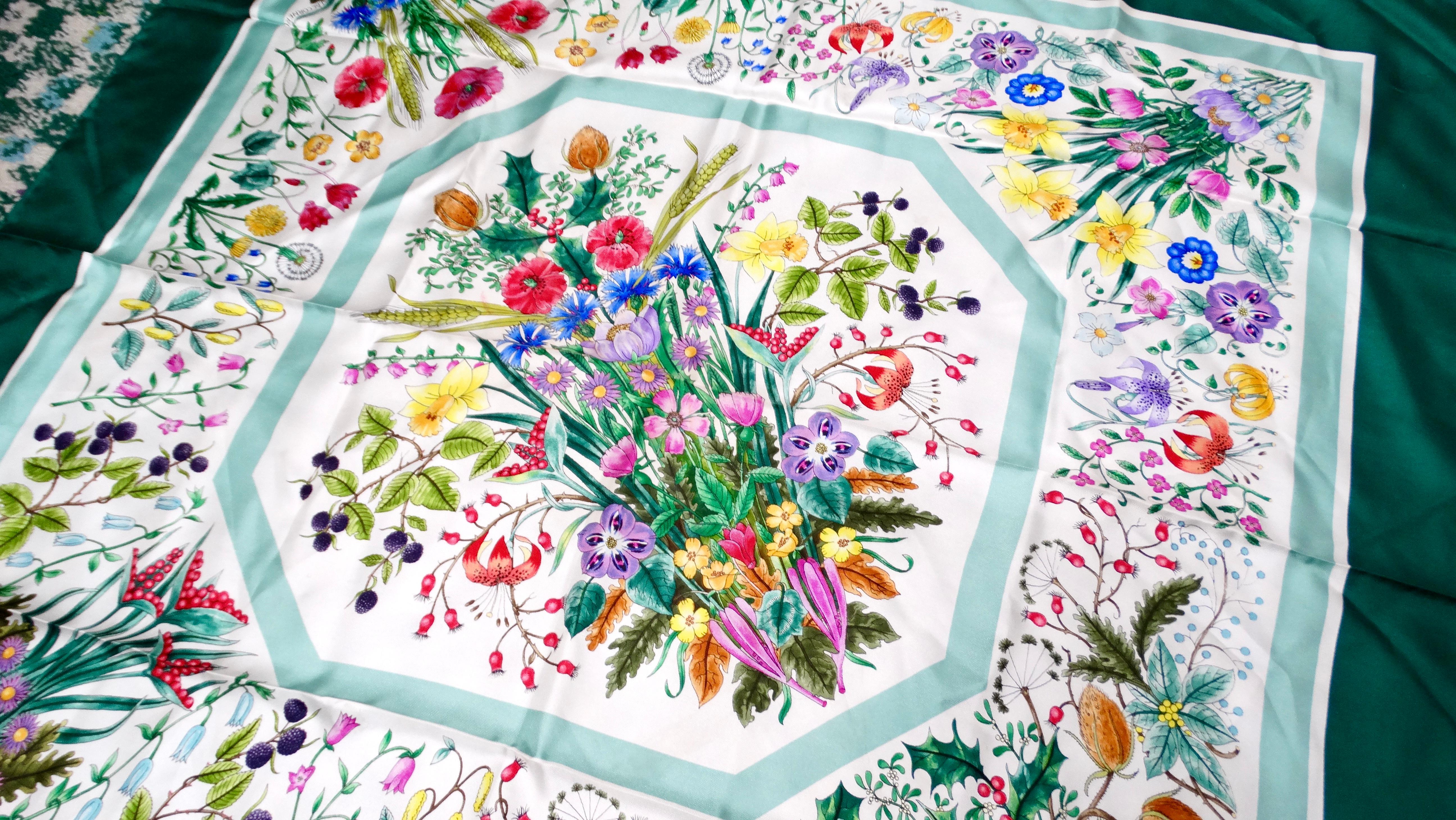 The Gucci Floral Bouquet Silk Green & White Scarf is a stunning accessory that effortlessly combines elegance with vibrancy. Featuring a rich, colorful floral bouquet print against a white base, this scarf is framed by a striking emerald green