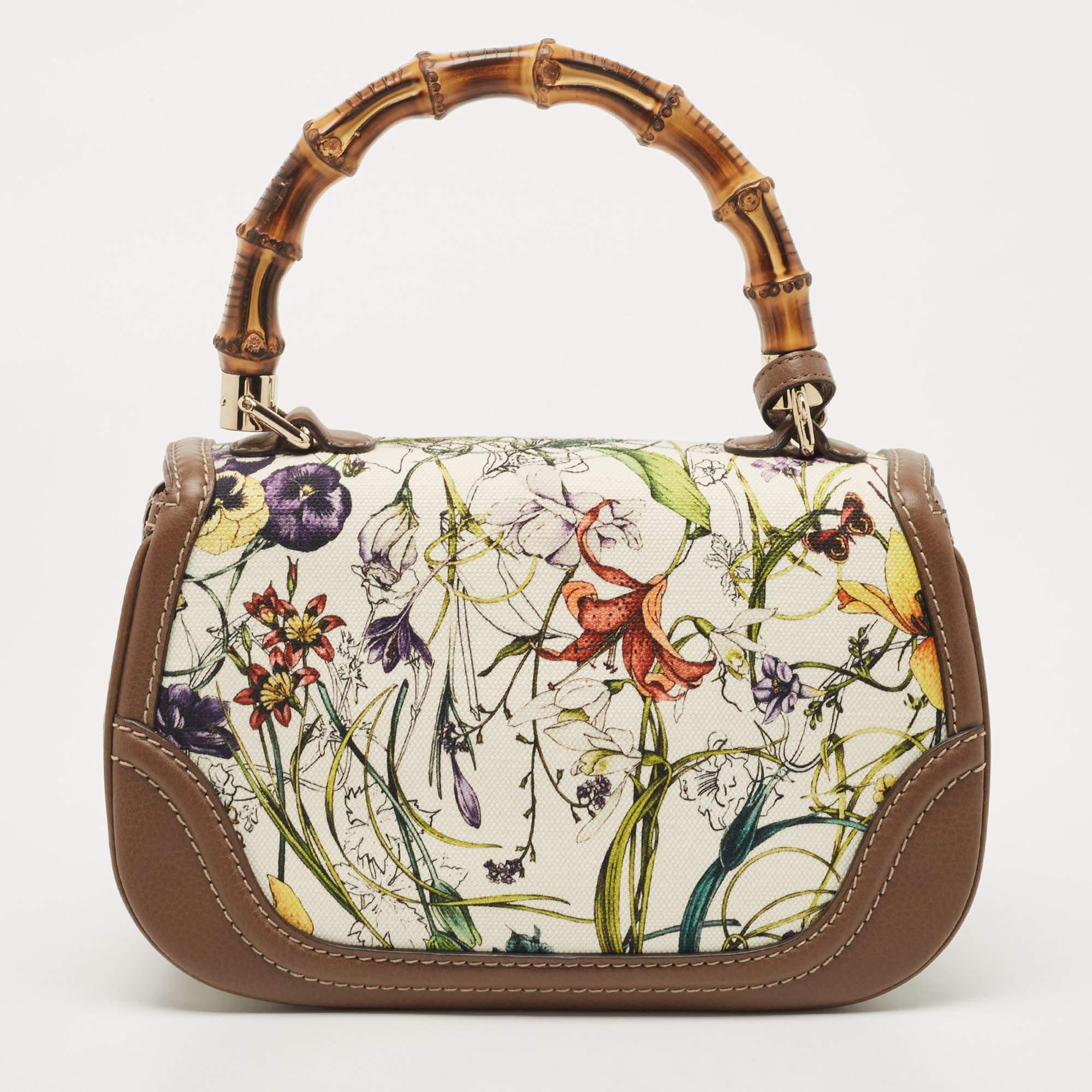This New Bamboo Gucci bag combines style and elegance into the ultimate everyday bag. Crafted from floral canvas and leather, it is accented with a signature bamboo top handle. Secured with a bamboo lock closure, the interior is lined with canvas