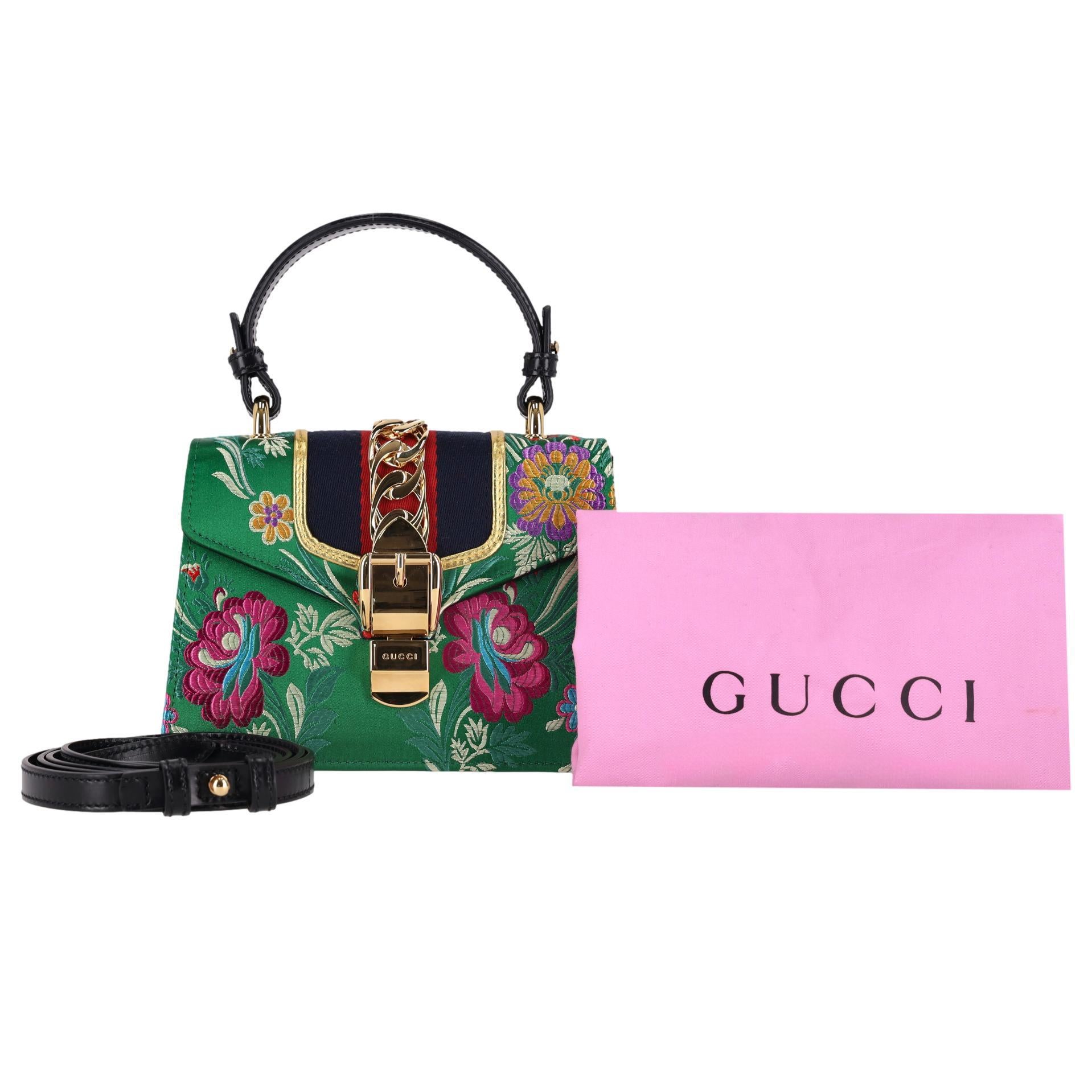 We Adore - Gucci Floral Jacquard Sylvie Small Top Handle Bag

Green satin 'Sylvie' bag designed with a multicoloured floral embroidery.

Featuring signature blue and red web stripe detail to the front flap.

Gold hardware with chain and branded