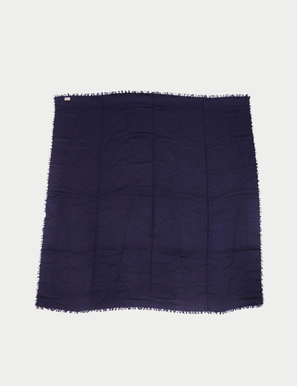 Gucci Marineblauer GG Monogram Schal mit Fransenkanten

Hüllen Sie sich in dezenten Luxus mit diesem marineblauen Schal von Gucci, der aus einer ultraweichen Mischung gefertigt und mit dem kultigen GG Monogramm-Muster verwebt ist. Mit zarten Fransen