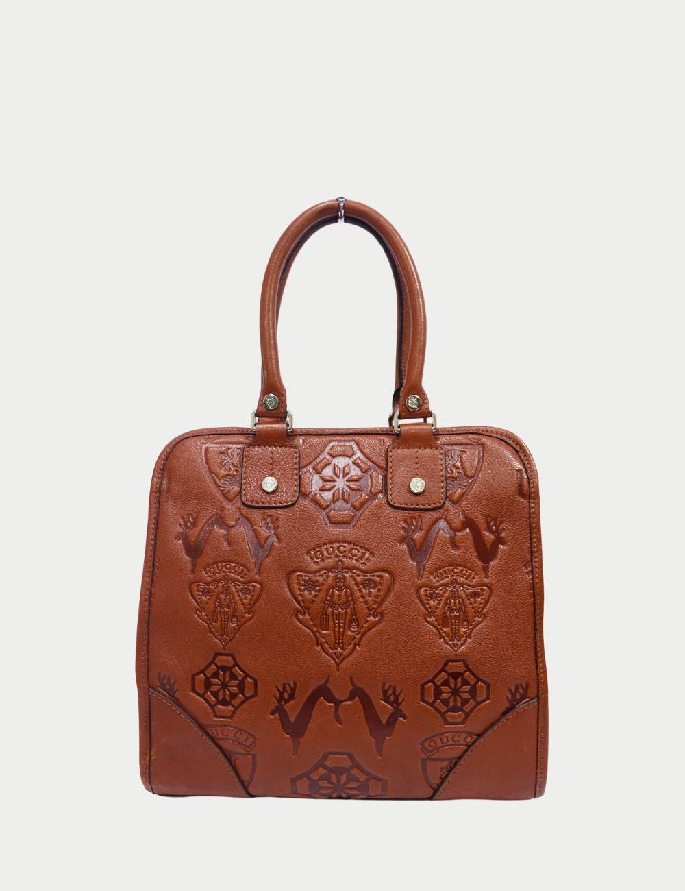 Fai una dichiarazione audace con questa borsa tote in pelle marrone goffrata di Gucci, che mette in mostra l'iconica maestria del marchio. Realizzata in ricca pelle marrone, la borsa è decorata con intricati motivi in rilievo e logo Gucci per un