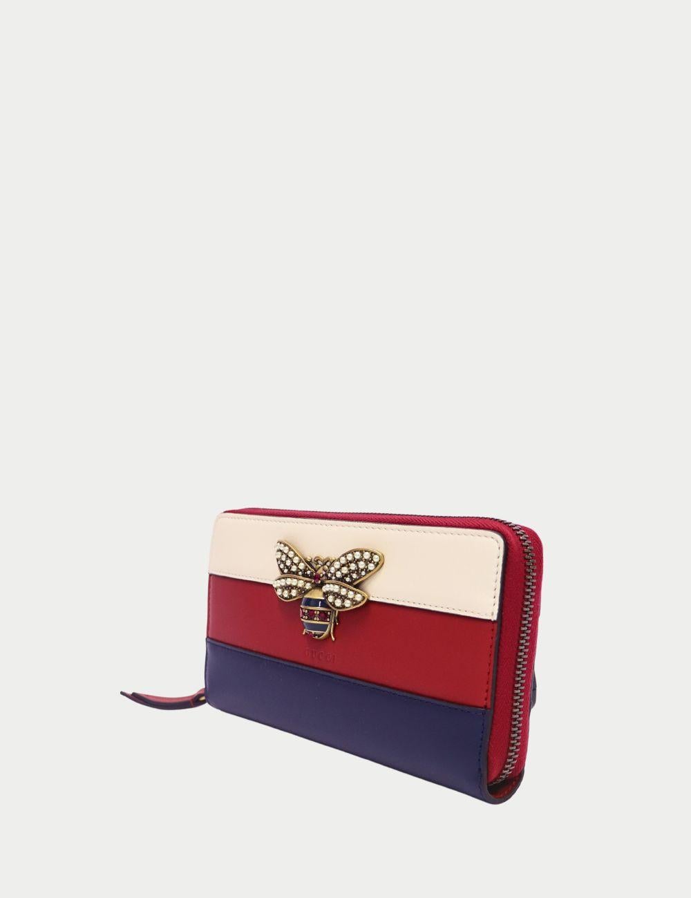 Fai una dichiarazione audace con questo portafoglio in pelle Sylvie di Gucci, un mix perfetto di artigianato di lusso e design giocoso.

Realizzato in pelle liscia con le tipiche strisce tricolori rosse, bianche e blu di Gucci, questo portafoglio è