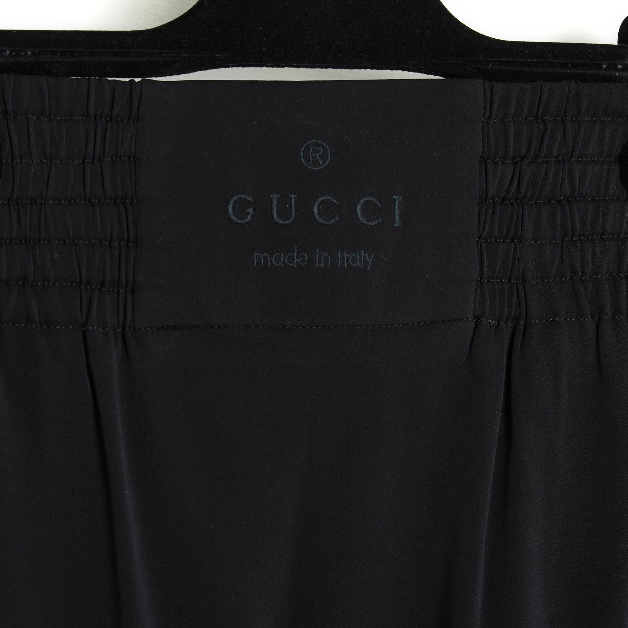 Short Gucci skirt in black silk crepe and elastane, boxer-style smocked elastic waist with smooth part embroidered with the Gucci logo on the front, 2 slit pockets closed with 2 Gucci logo snaps, unlined. Size 38IT or 34FR or UK 6 and US4: size
