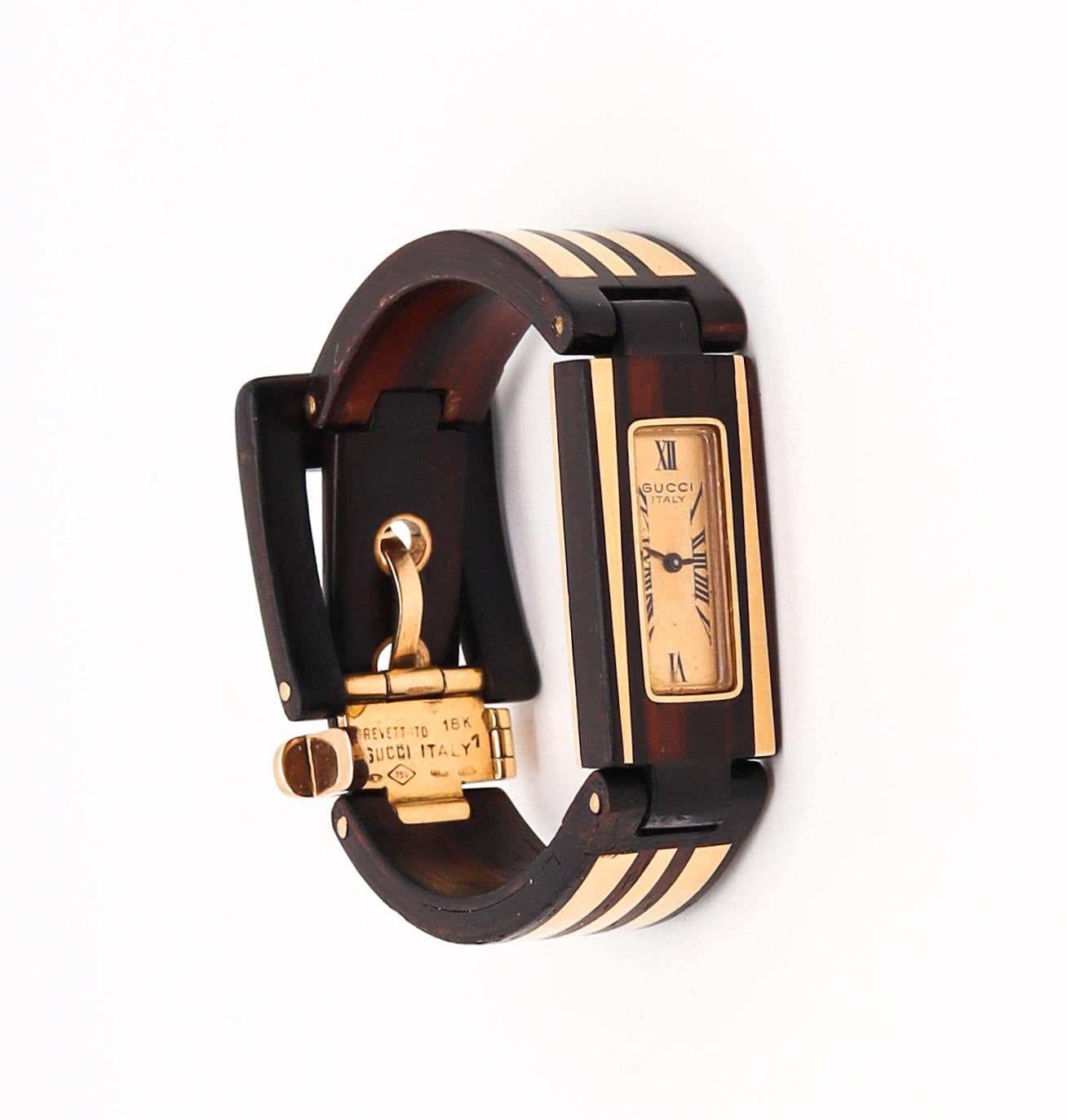 Eine Retro-Uhr für das Handgelenk, entworfen von Gucci Frankreich.

Ein äußerst seltenes Stück, das 1968 in Paris vom Haus Gucci entworfen wurde. Diese ungewöhnliche Armbanduhr mit Schnalle wurde sorgfältig aus natürlichem Makassar-Ebenholz