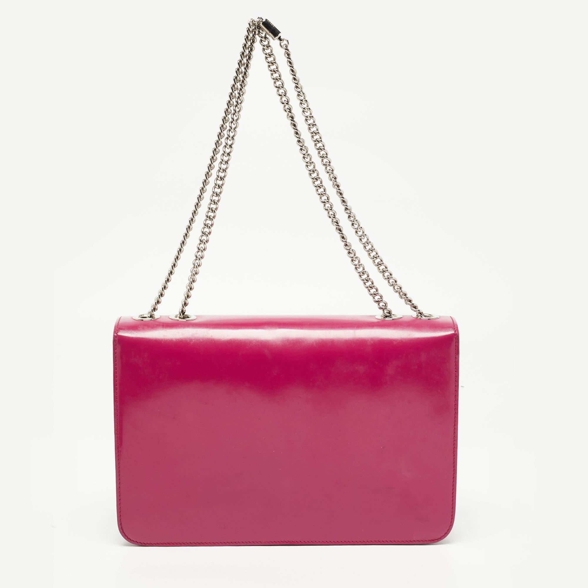 Add a touch of minimized elegance when you style this Gucci handbag with your favorite outfits. Made in Italy from glossy leather, the bag comes in a fuchsia shade and a front flap adorned with an interlocking G logo. The creation is equipped with a