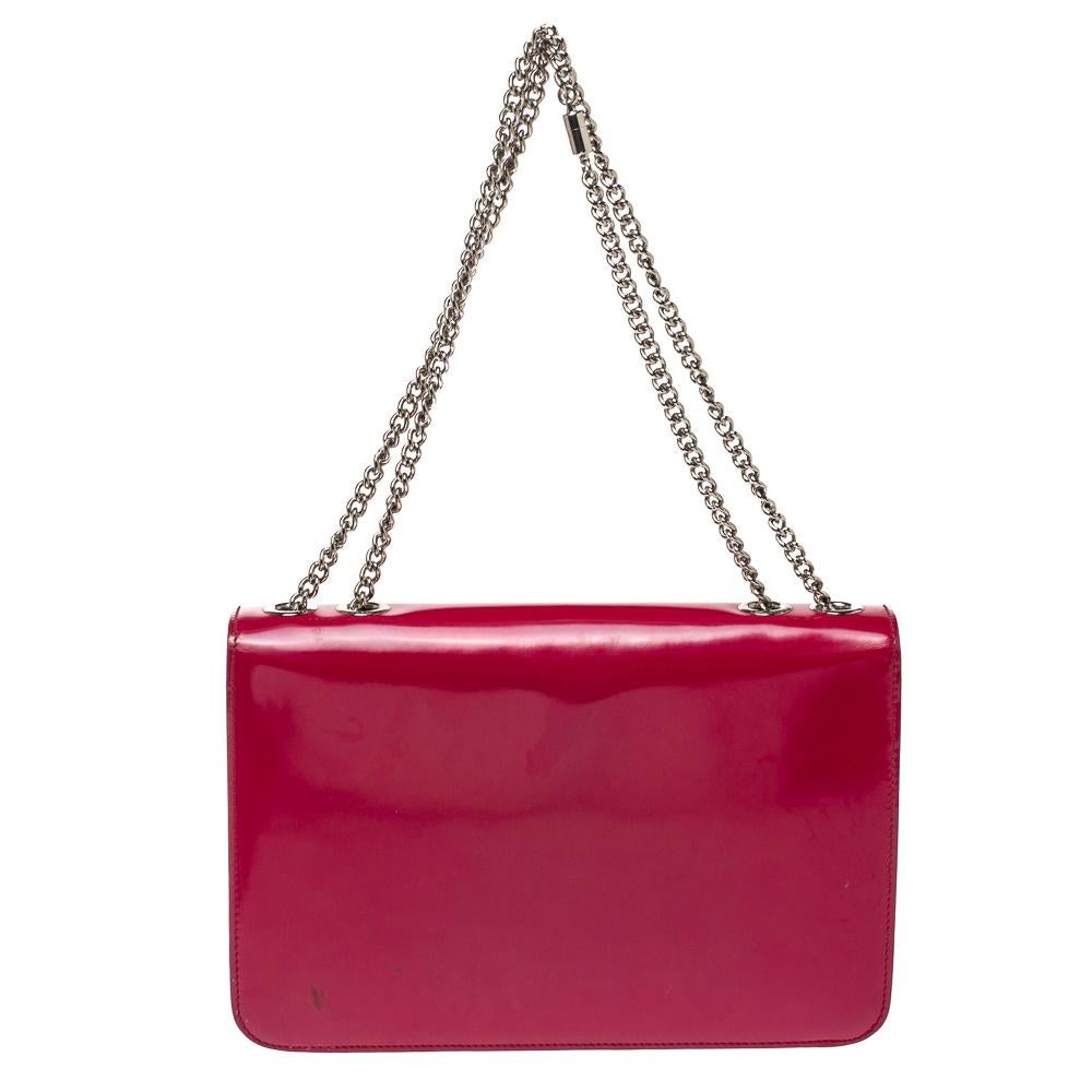 Add a touch of minimized elegance when you style this Gucci handbag with your favorite outfits. Made in Italy from patent leather, the bag comes in a fuchsia shade and a front flap adorned with an interlocking G logo. The creation is equipped with a