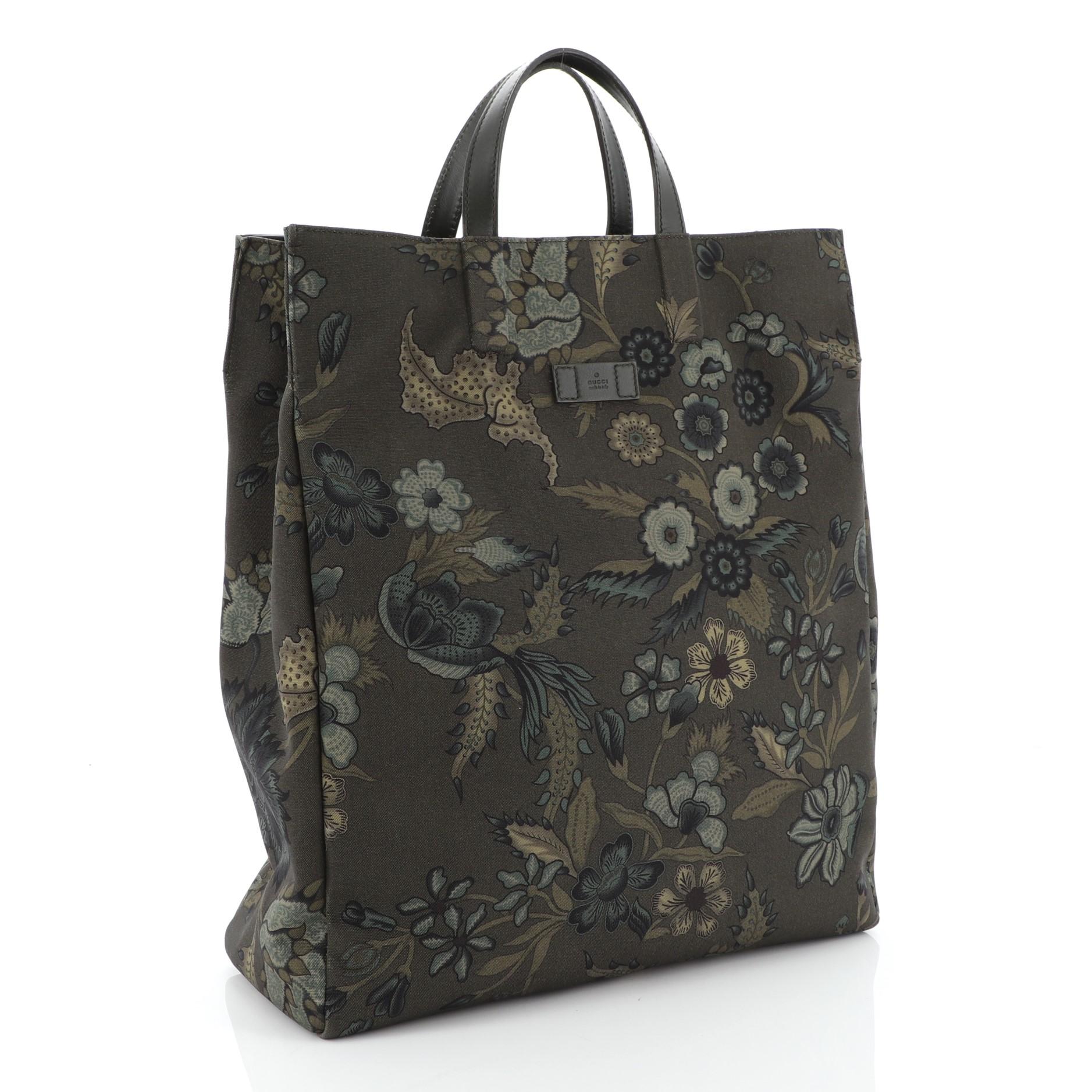 This Gucci G-Active Knight Tote Flora Canvas Tall, crafted in green flora printed canvas, features dual flat leather handles and silver-tone hardware. Its wide-open top showcases a green nylon interior with zip pocket. 
Estimated Retail Price: