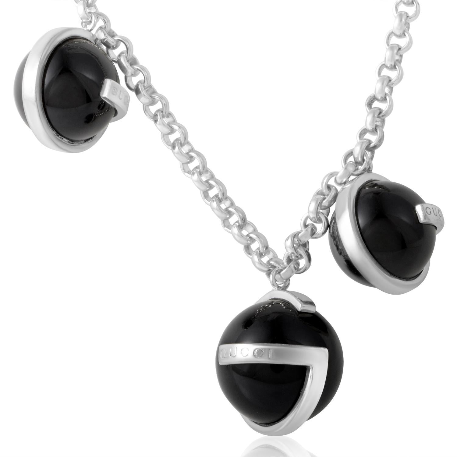 A delightful yet edgy bracelet by Gucci creates a high fashion impression. The silver rolo chain holds three onyx beads, two that measure 12mm and one that measures 14mm, in intriguing G shaped settings that are gracefully engraved with the Gucci