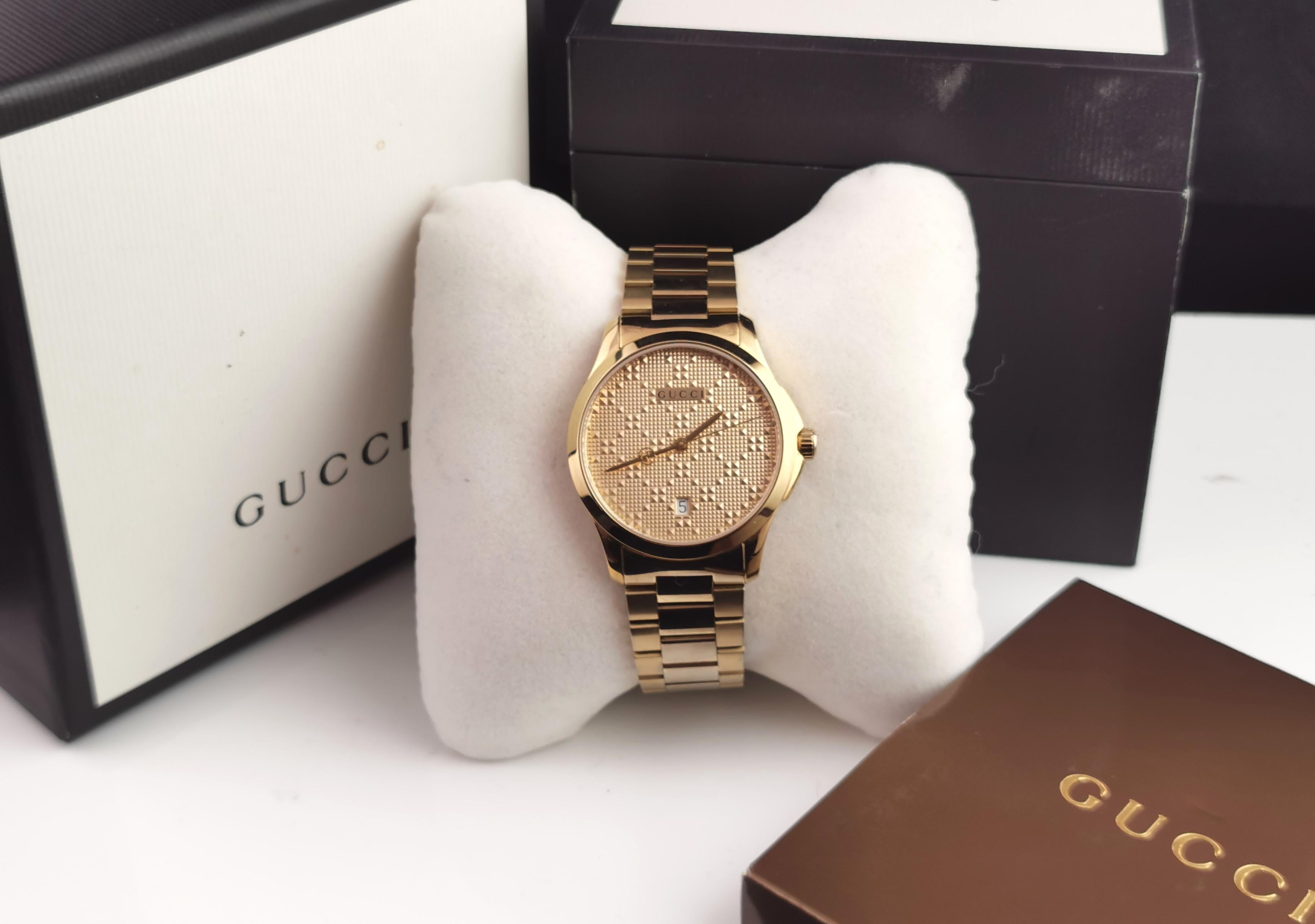 This is truly a luxury watch produced by Gucci.

It is the Gucci G Timeless 126.4 gentlemans wristwatch.

Fully gold tone with a chunky heavy bracelet strap and textured gold tone dial the second hand featuring the Gucci logo and branded to the