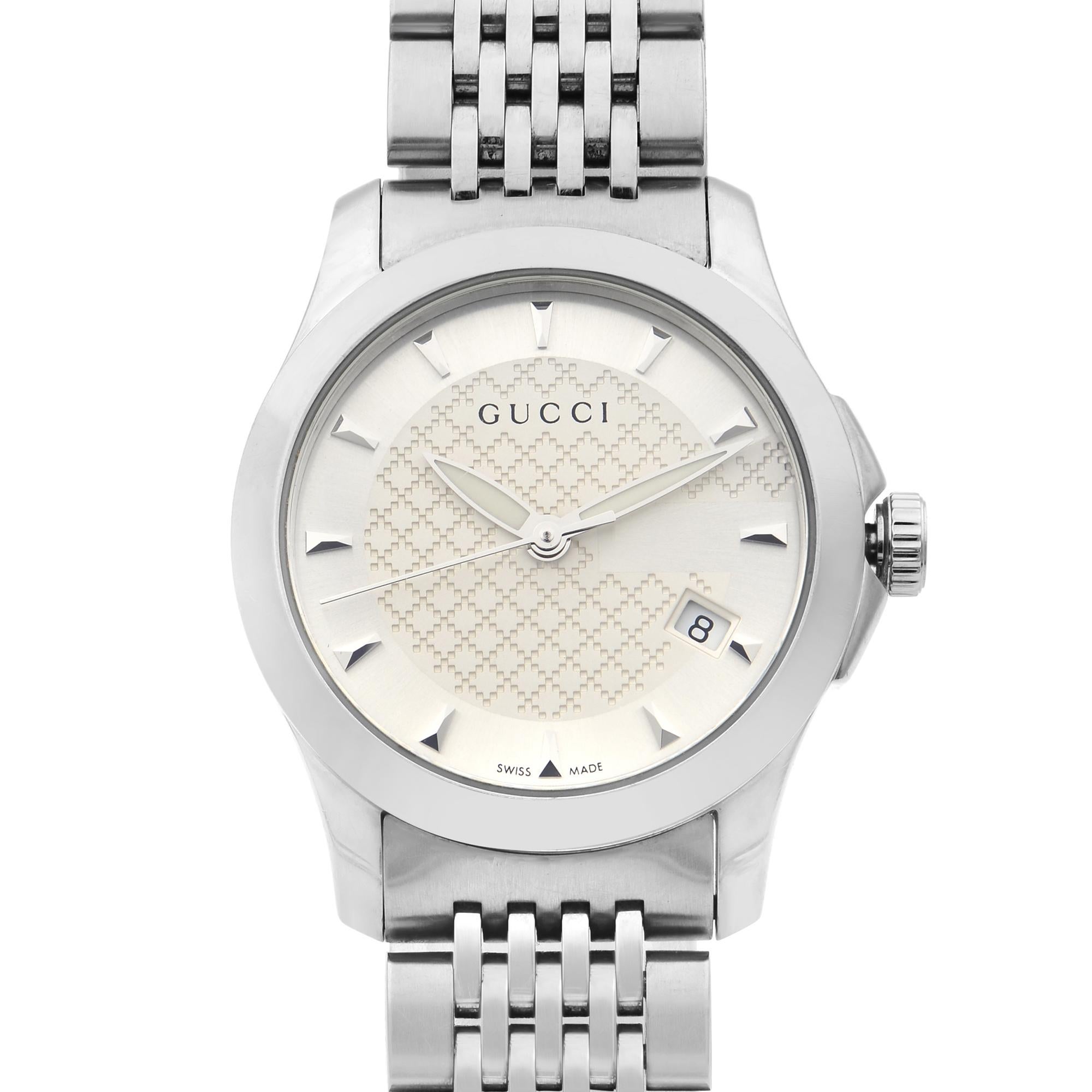 This display model Gucci G-Timeless YA126501 is a beautiful Ladie's timepiece that is powered by quartz (battery) movement which is cased in a stainless steel case. It has a round shape face, date indicator dial and has hand sticks style markers. It