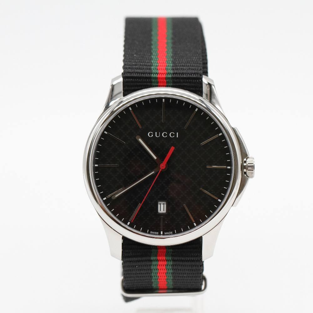GUCCI G-TIMELESS Watch YA126321 Brand New Watch. Stainless steel case 39mm excluding crown. Case thickness 8mm. Sapphire crystal. Black dial. Fabric strap. Quartz movement. Water resistant 5atm. Delivered with box. Ref:D363887FJ