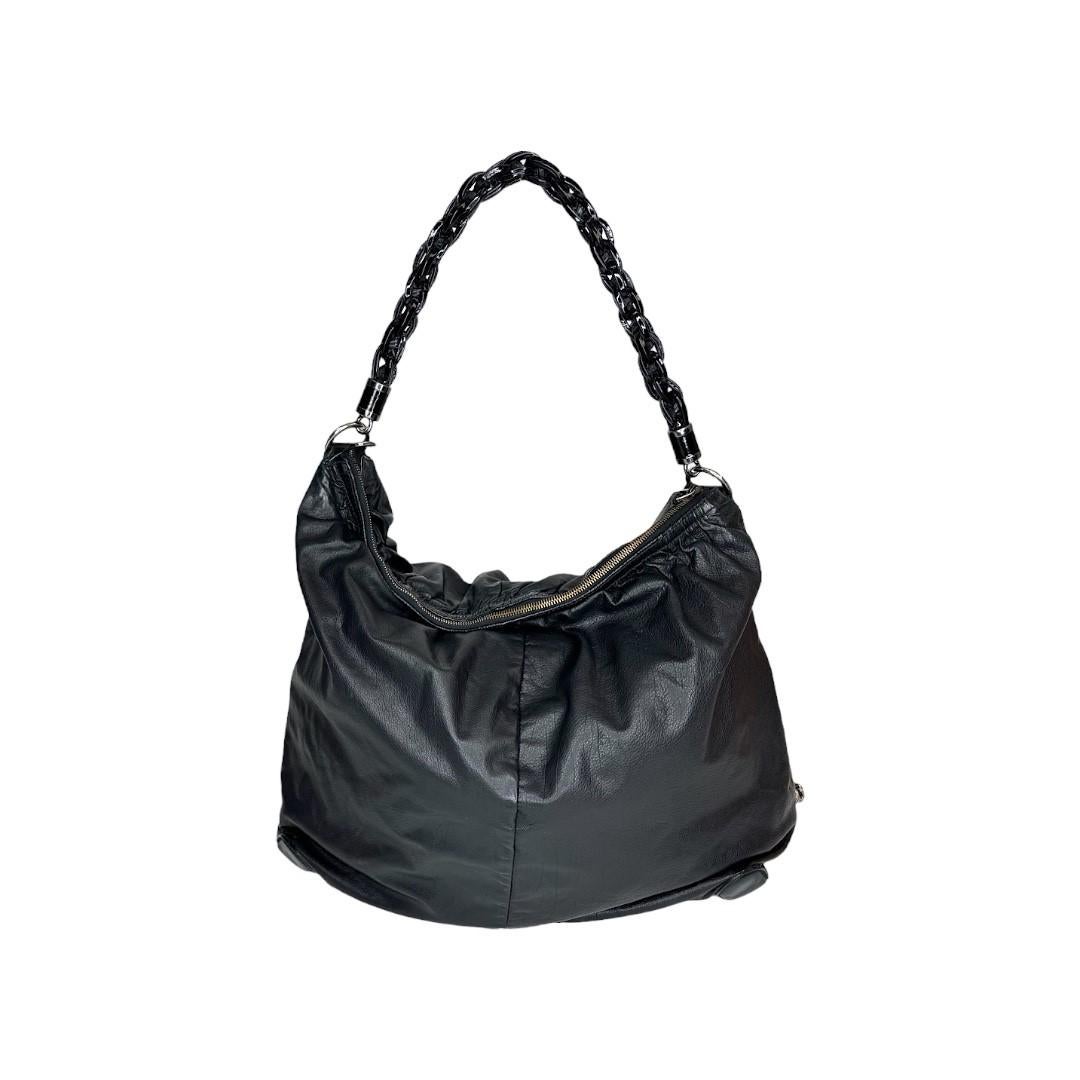 This Gucci Large Galaxy Hobo was made in Italy and it is finely crafted of a black leather exterior with silver-tone hardware features. It has a chain-link patent leather shoulder strap. It has a side zipper pocket. It has a zipper closure that