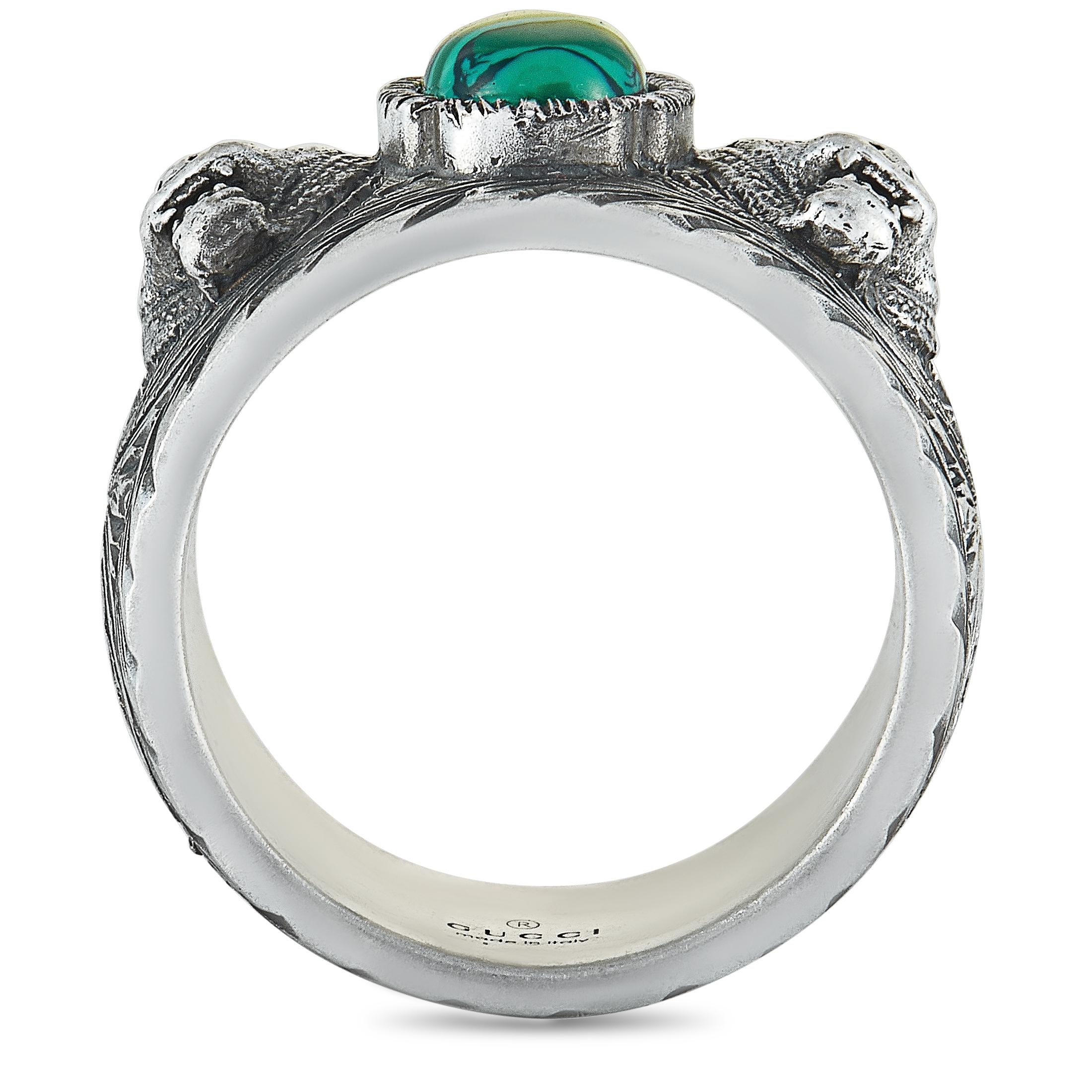 The Gucci “Garden” ring is made out of silver and a green resin stone and weighs 19.1 grams. The ring features an intricately engraved pattern and feline head motifs from the Gucci Garden, and boasts band thickness of 14 mm and top height of 6 mm,