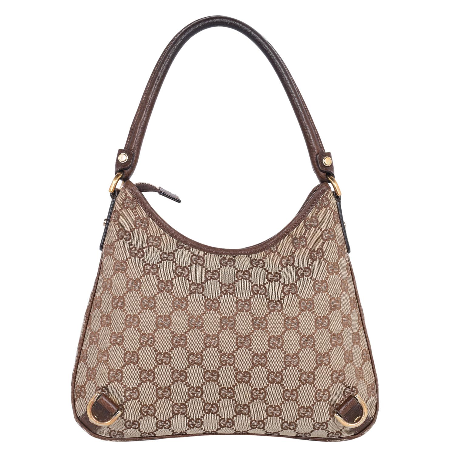 Authentic, pre-loved Gucci GG brown monogram Abbey shoulder bag. Features: brown canvas with leather trim, gold hardware, zipper top closure, brown textile interior lining with zipper slip pocket and patch pocket, round leather shoulder