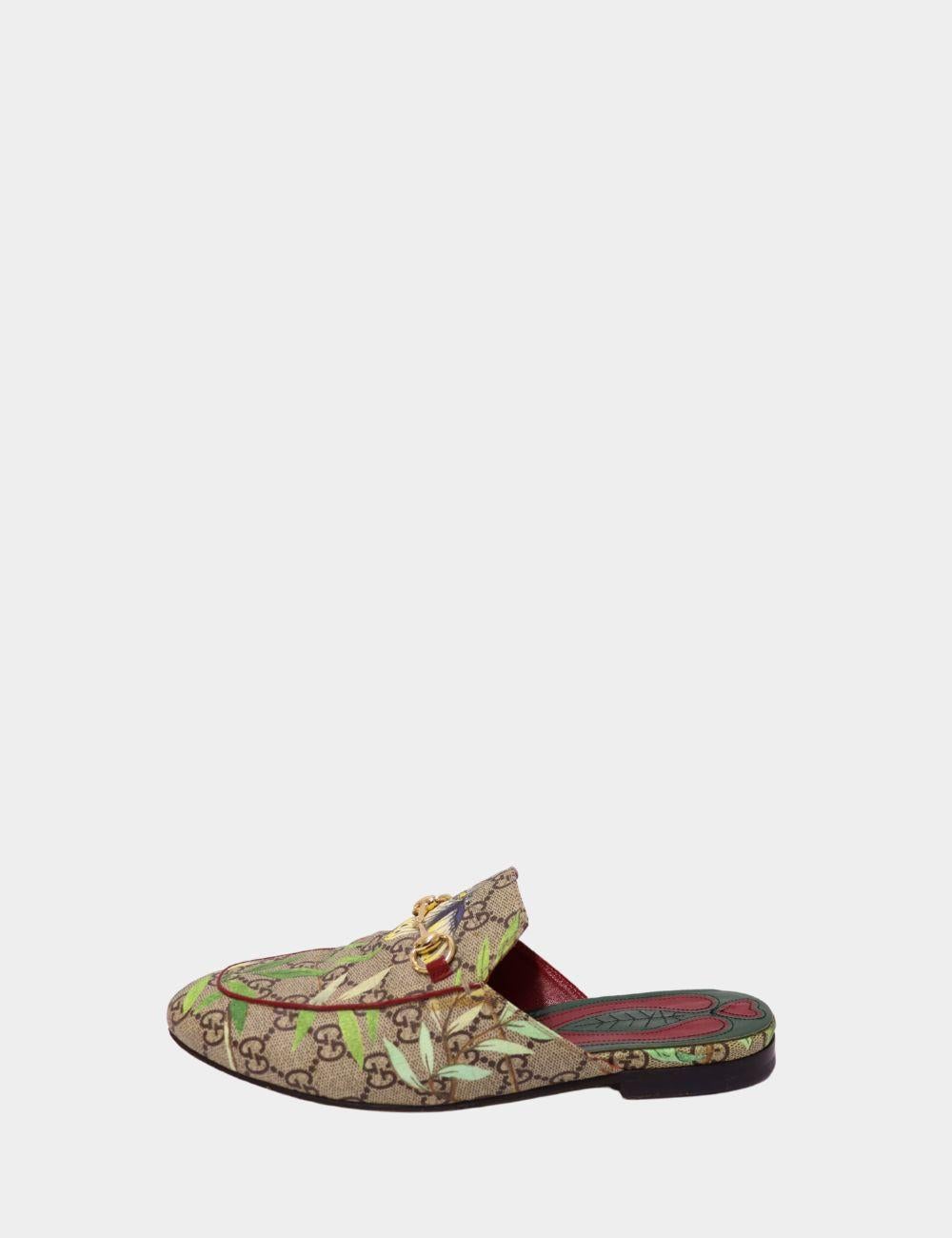 Make a bold statement in these Gucci GG canvas slipper loafers, showcasing the iconic monogram print overlaid with a vibrant floral and bird motif. Designed with a sleek backless silhouette and finished with the signature gold horsebit hardware,