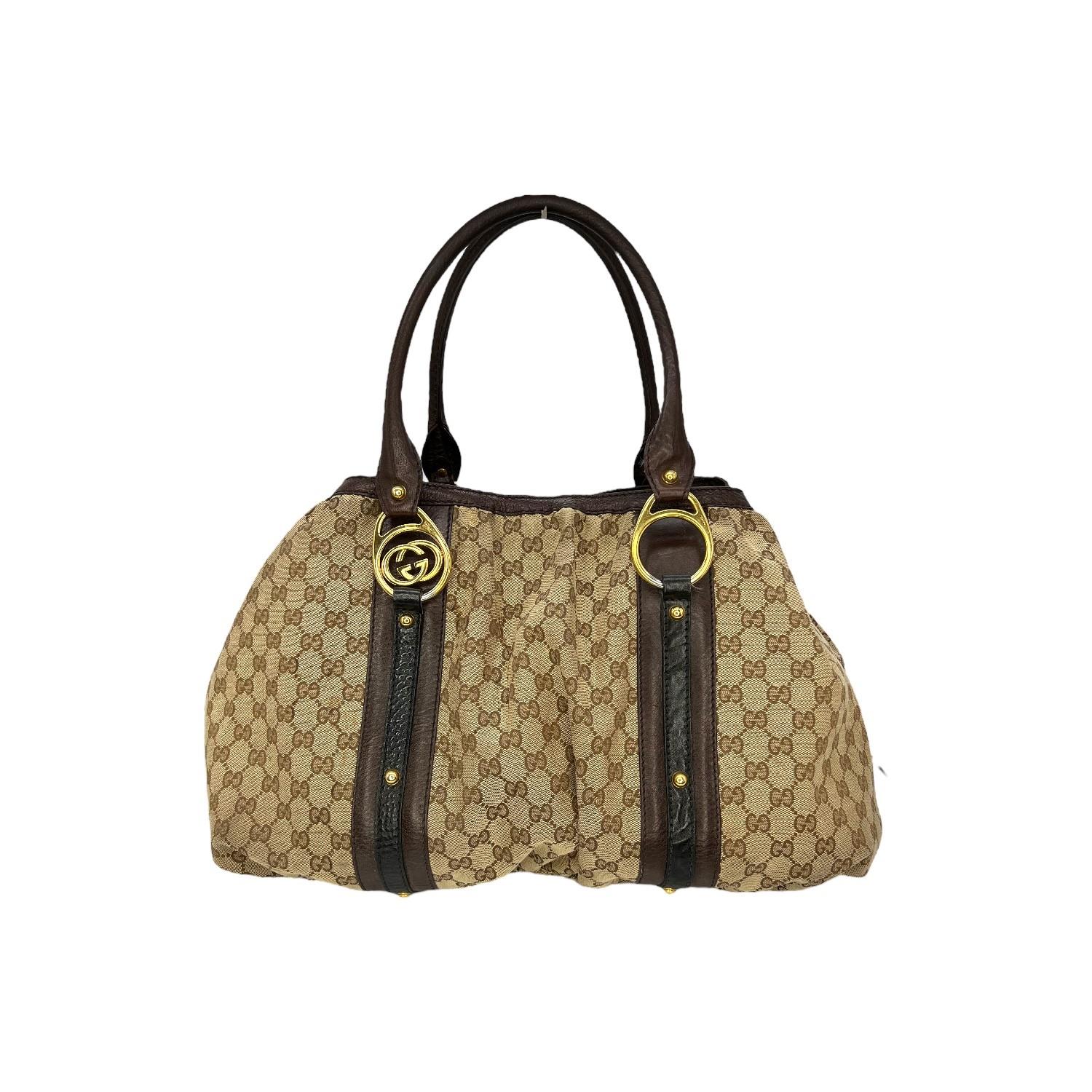 This Gucci GG Canvas Interlocking Icon Tote was made in Italy and it is finely crafted of the Gucci Interlocking GG coated canvas with leather trimming and gold-tone hardware features. It has dual rolled leather handles. It has a magnetic snap