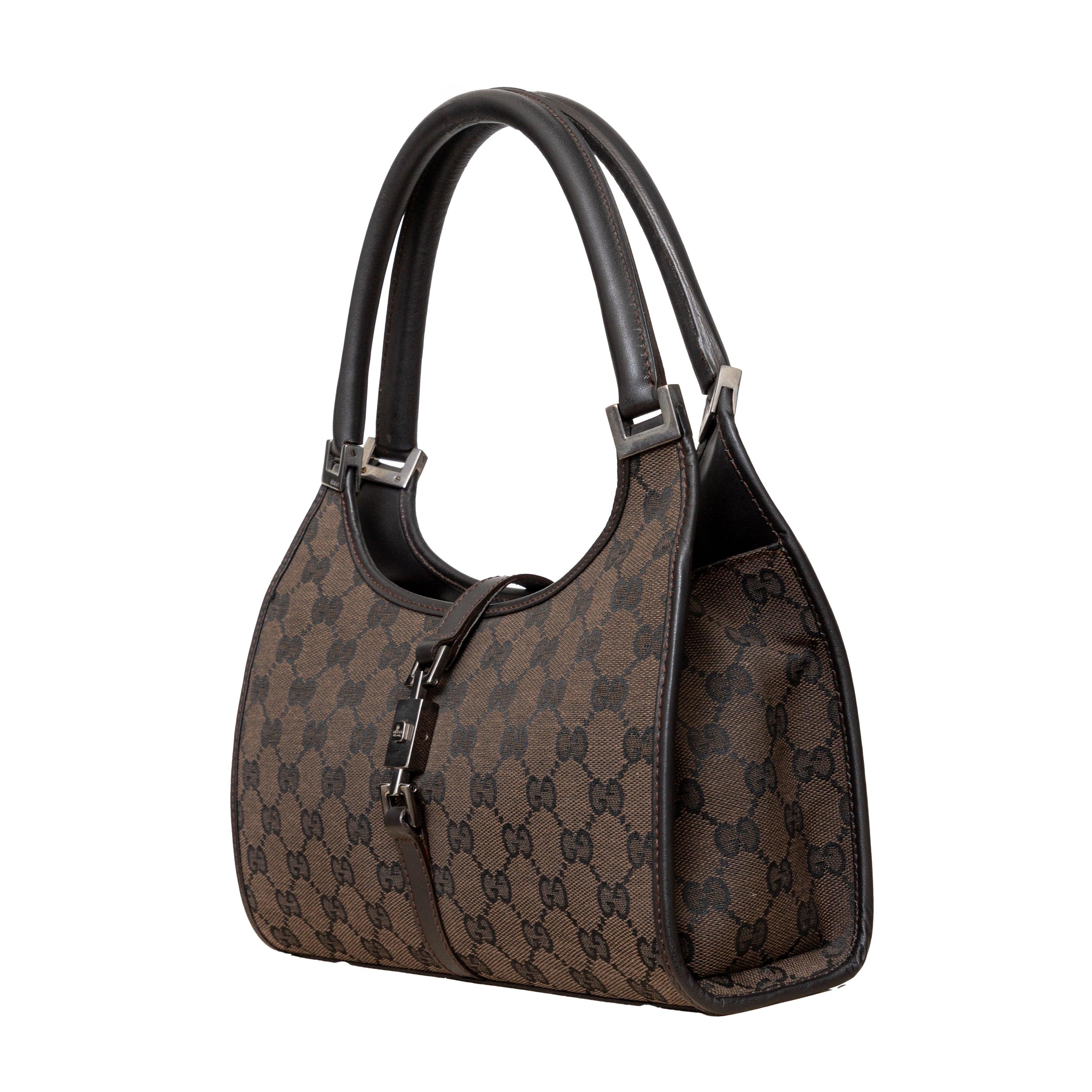 Luxurious brown GG canvas bag with silver-tone hardware, dark brown leather trim, rolled leather straps, and piston-lock closure for elegance and practicality. 
 Measurement: Height:18;Width:25.5;Depth:6;Shoulder Drop:16 
 Material: Canvas